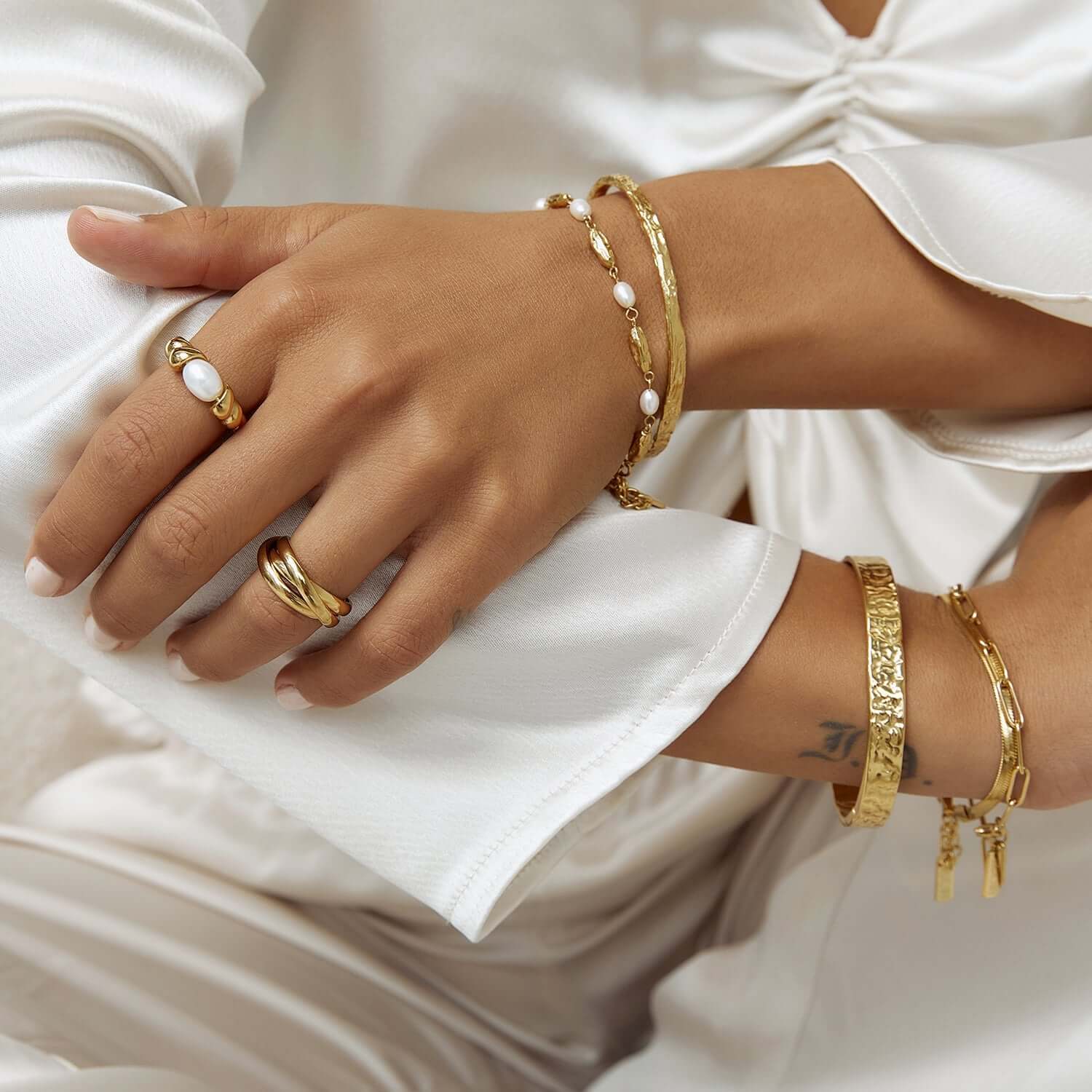 Model wearing gold cuff bracelet stack