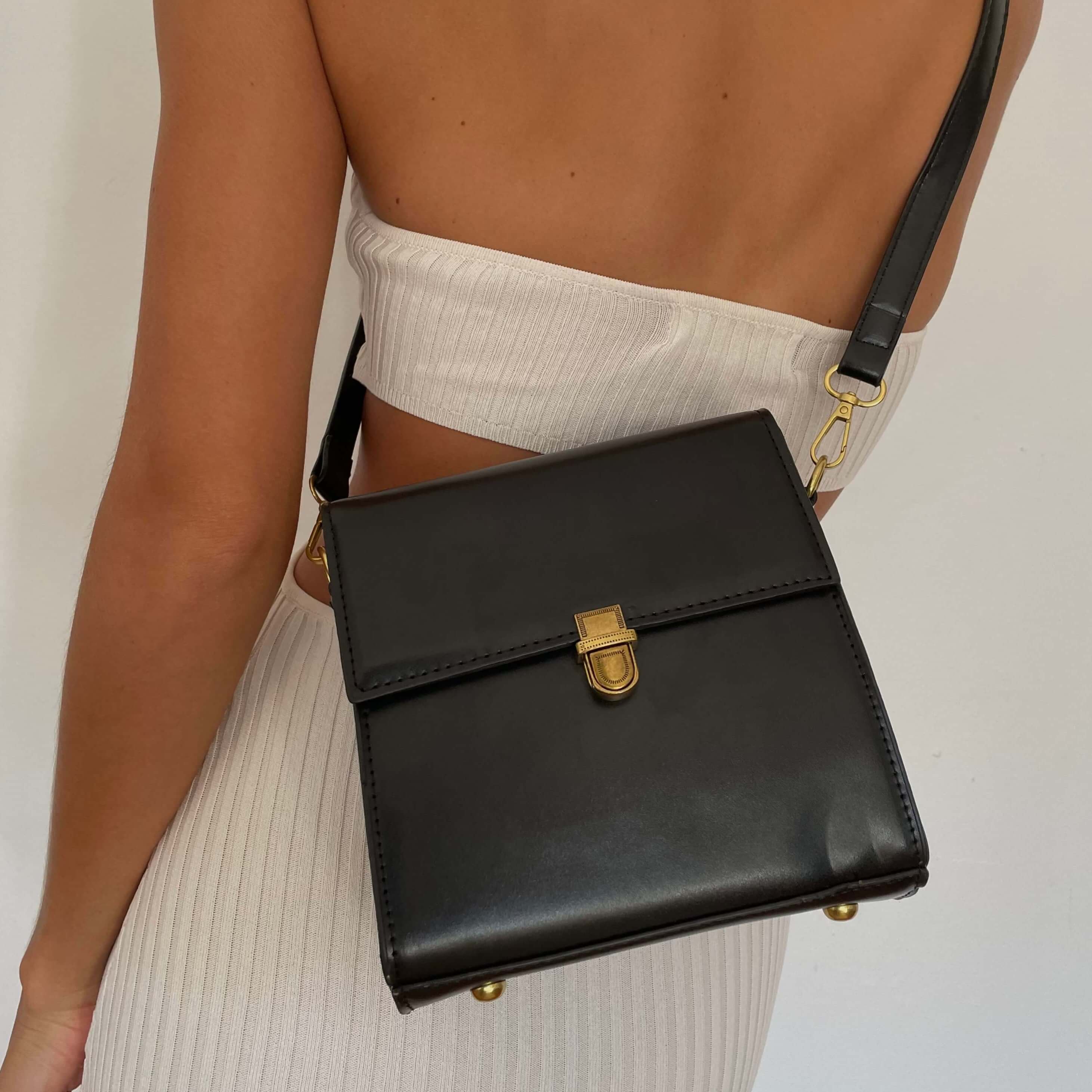 Model wearing a Square black leather crossbody bag