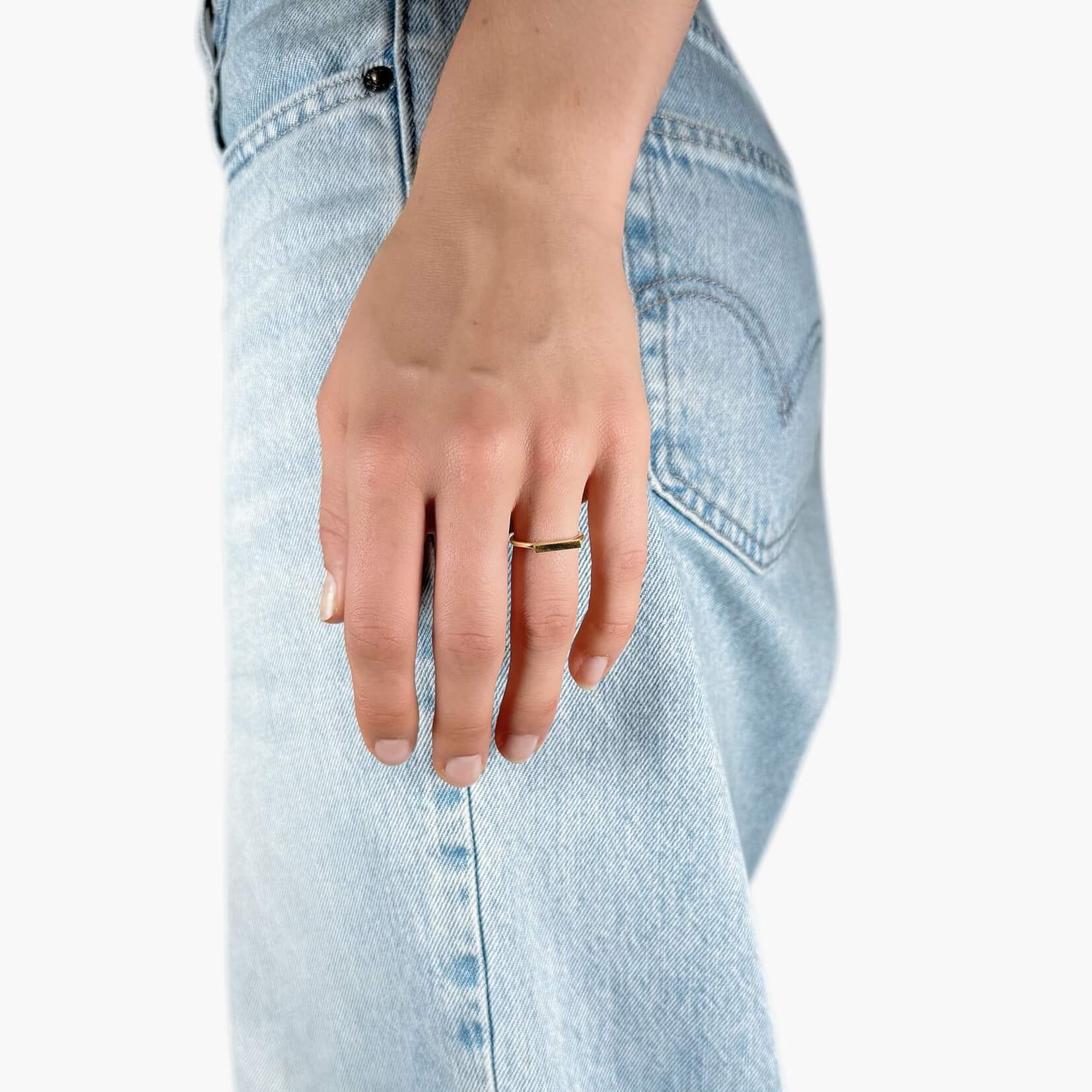 Model wearing simple gold band ring