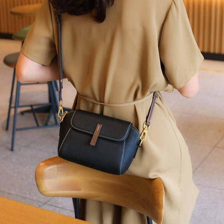 A woman carrying a black mini crossbody bag