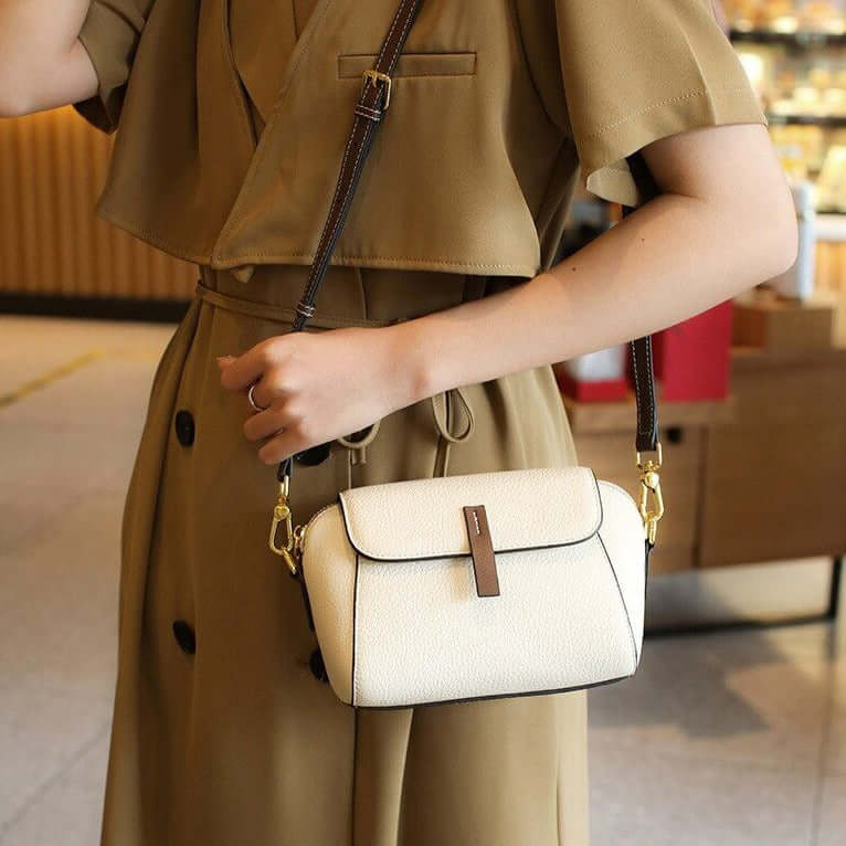 A woman carrying a white mini crossbody bag