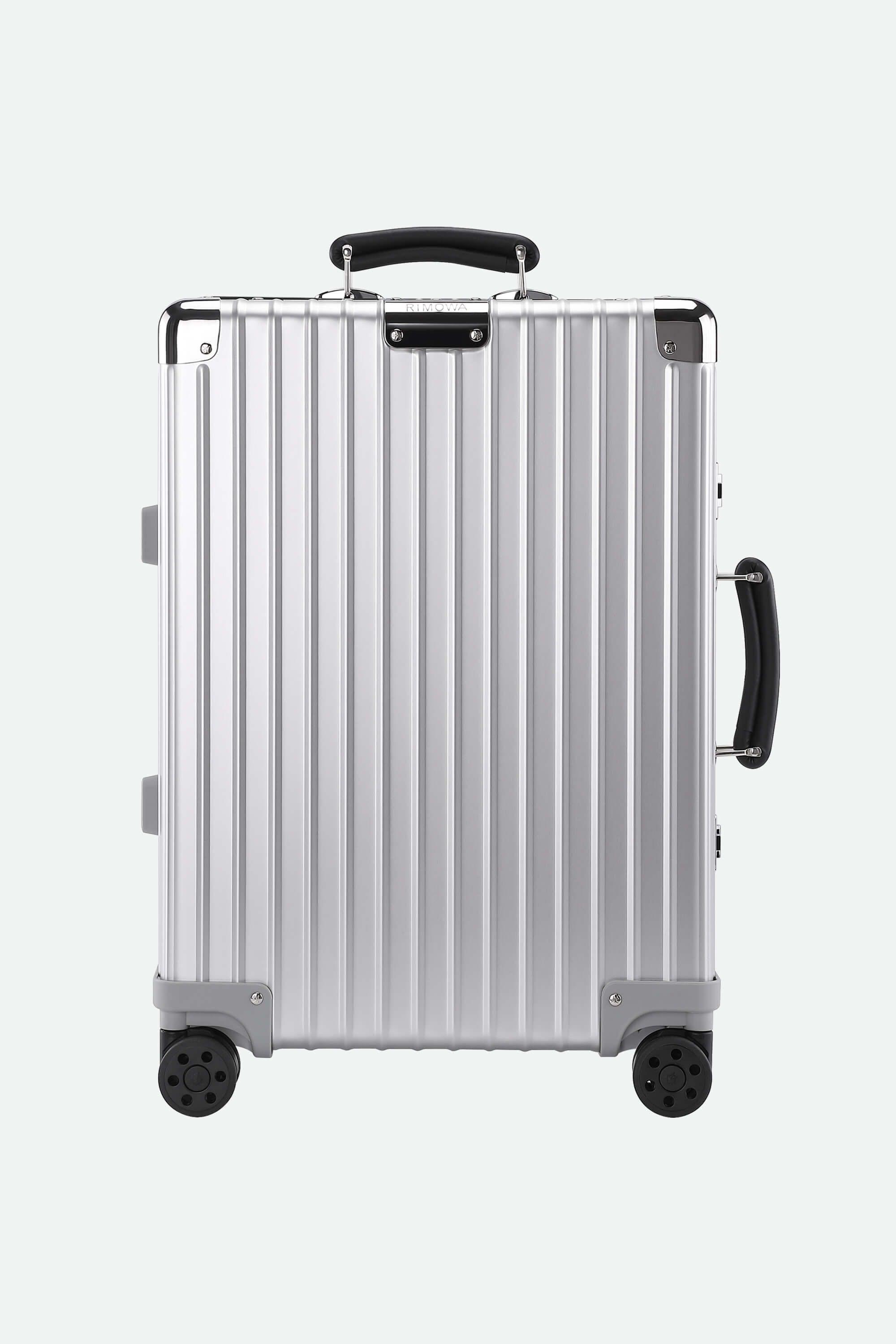 Silver suitcase with black handles and wheels on a white background