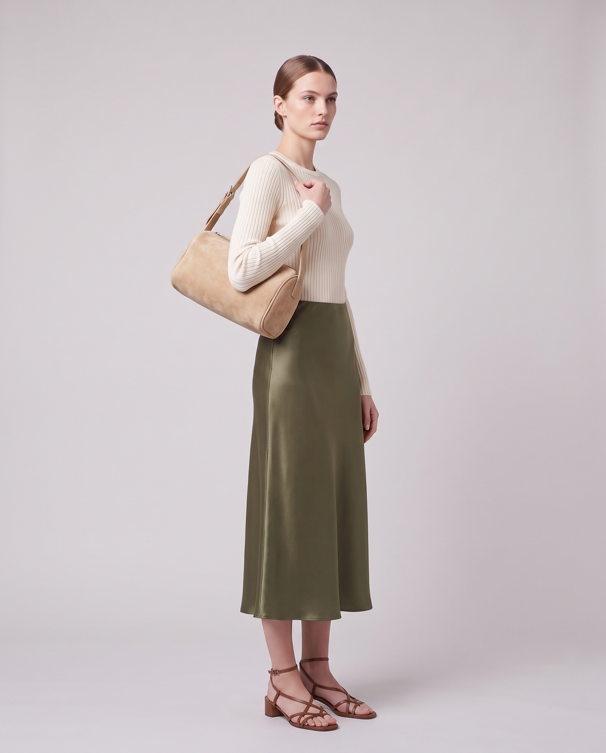Model carrying the Alba barrel shoulder bag in Beige suede on the shoulder