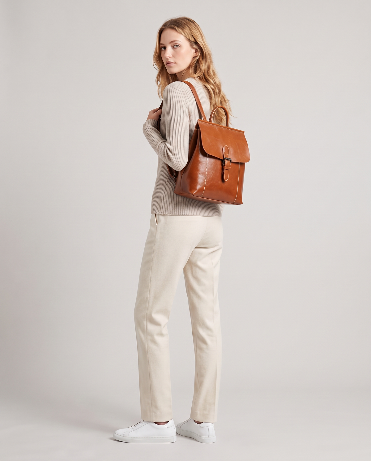Ambler waxed leather backpack in Brown – model wearing it on her back, full length