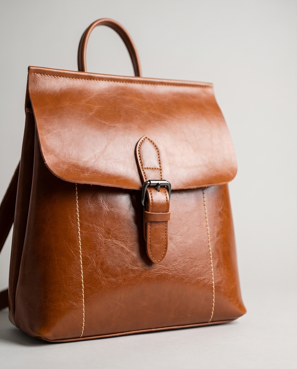 Ambler waxed leather backpack in Brown – close-up of the buckle and contrast stitching