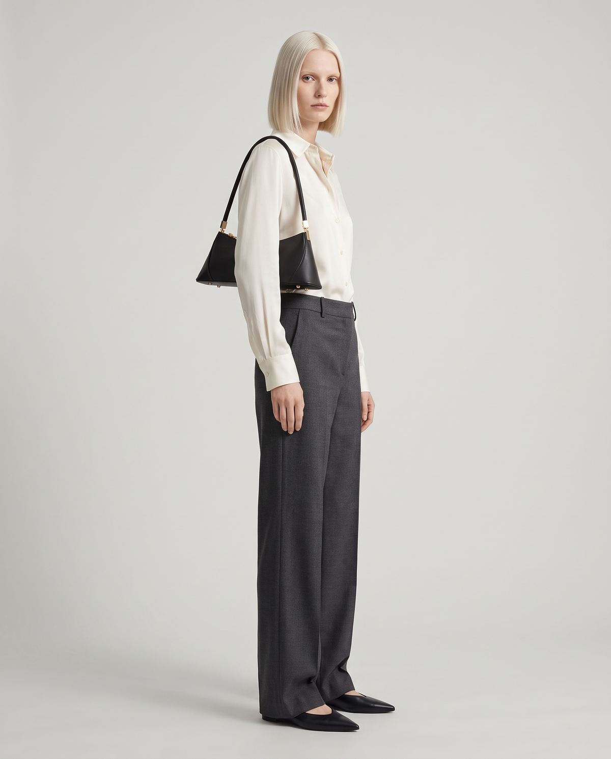 Arc leather shoulder bag in Black – model wearing it on her shoulder, full length
