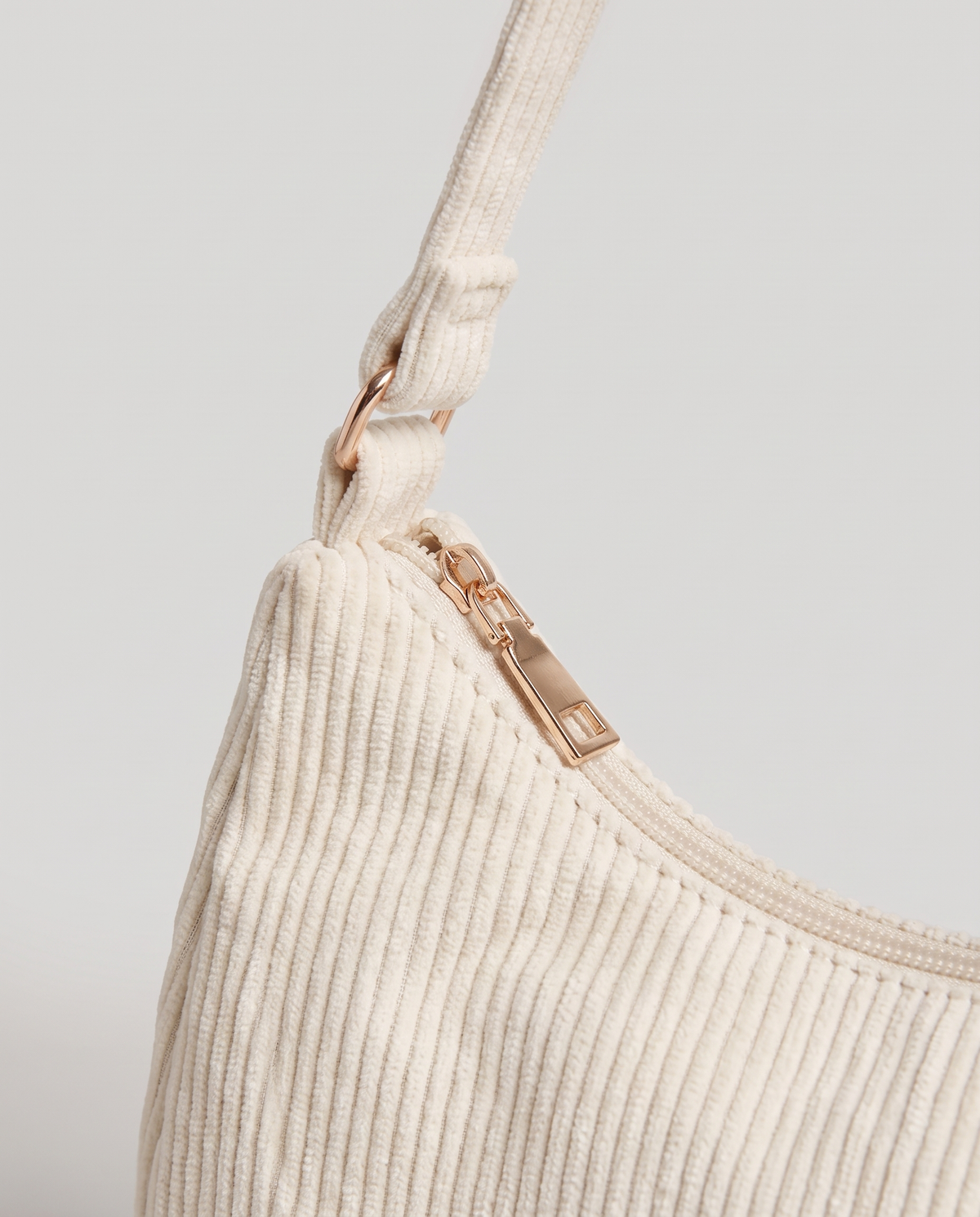 Aura corduroy shoulder bag in White – close-up of the corduroy, zip and strap fitting