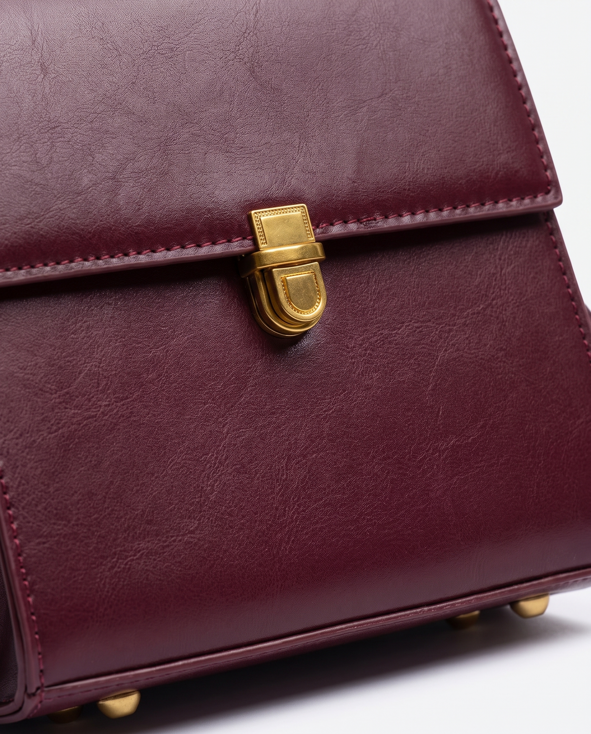 Bloc square vegan leather crossbody bag in Cherry – close-up of the gold push-lock clasp