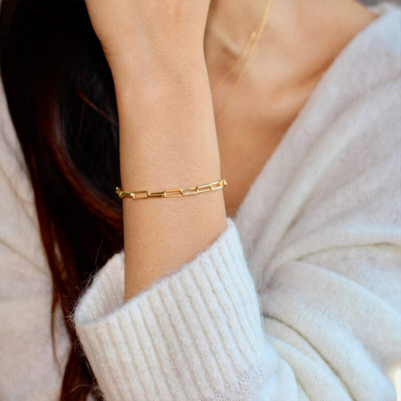 Model wearing gold paperclip bracelet