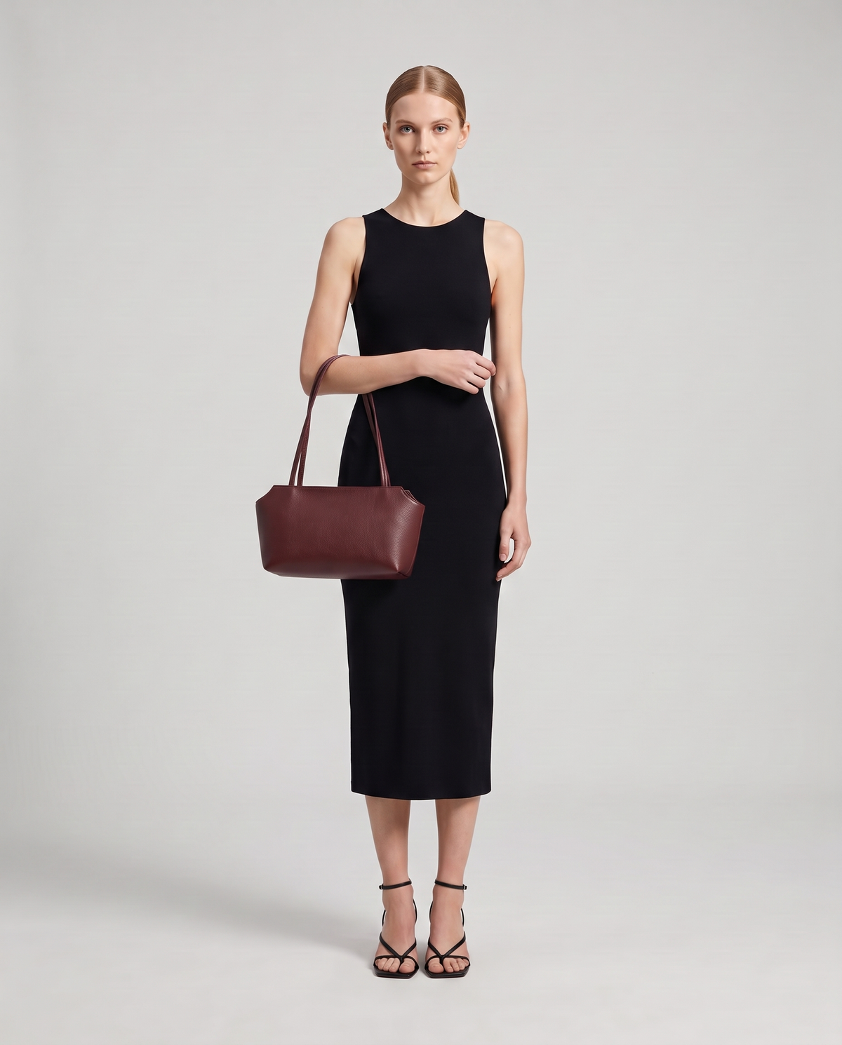 Model with the Capri leather shoulder bag in burgundy, full length