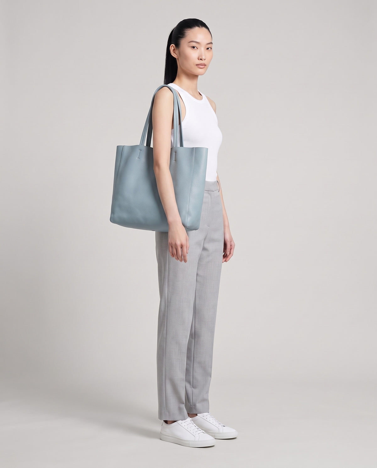 Model with the Costa leather tote in blue, full length