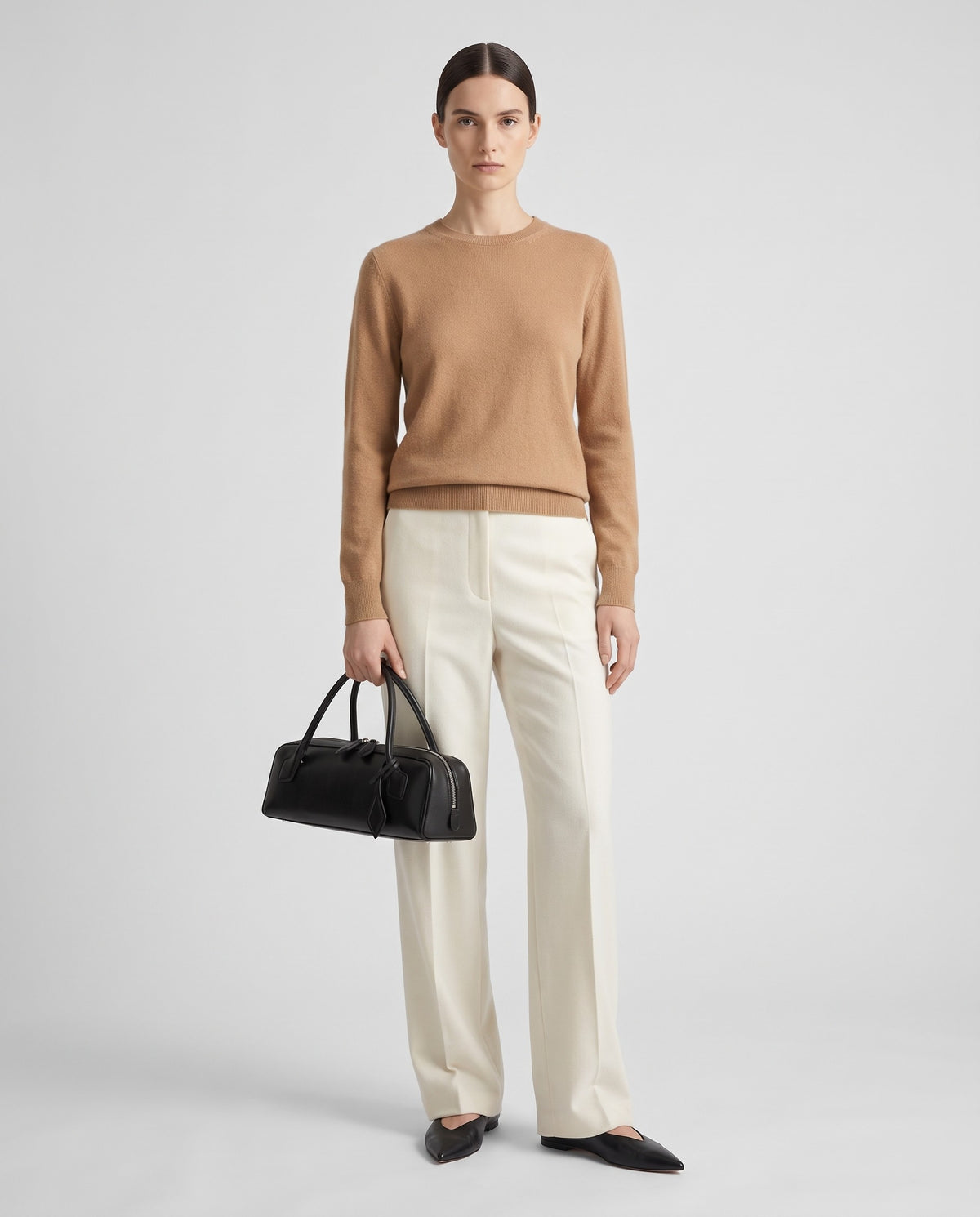 Curve leather barrel bag in Black – model holding it, full length
