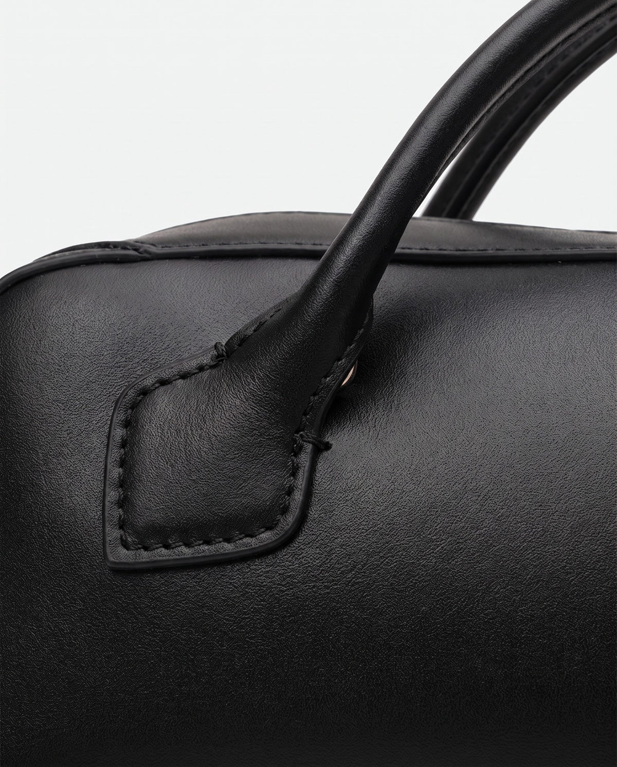 Curve leather barrel bag in Black – close-up of the leather