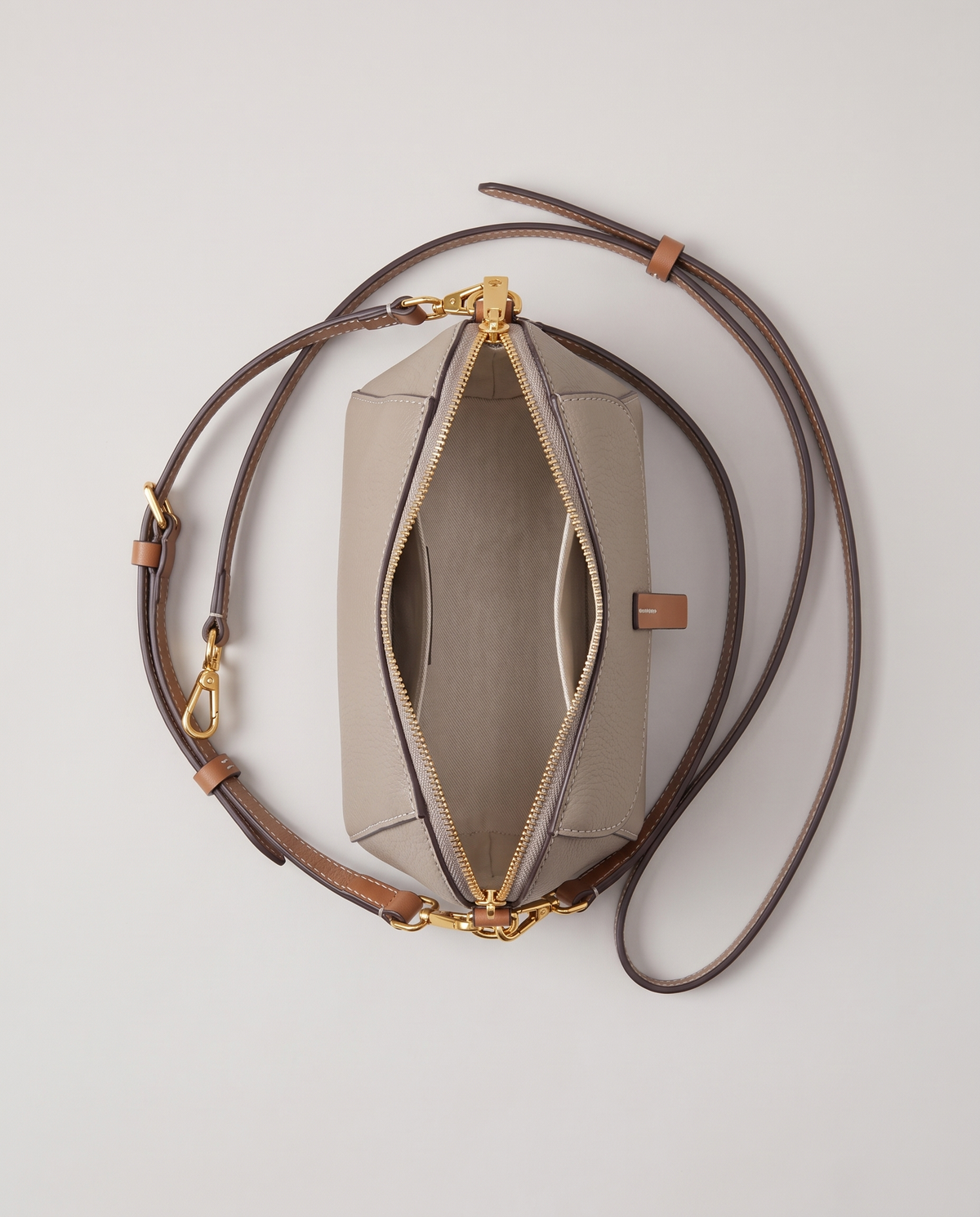Elara mini leather crossbody in Grey – open, showing the lined interior