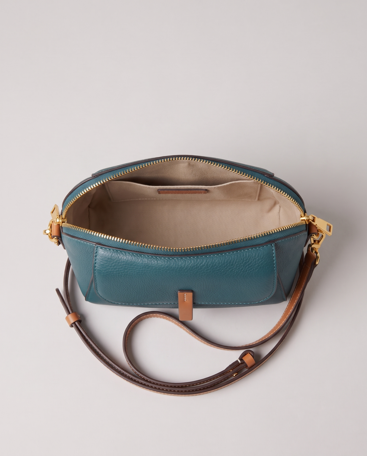 Elara mini leather crossbody in Teal – open, showing the lined interior