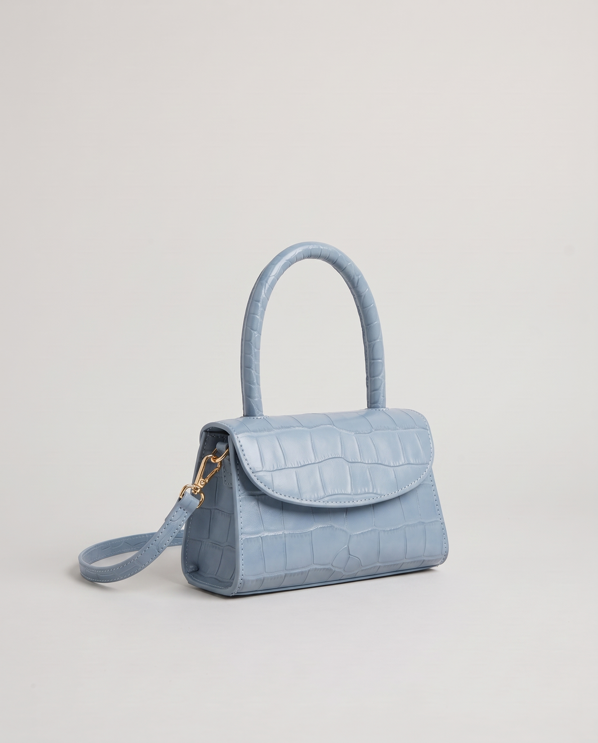 Fern mini croc top-handle bag in Blue – three-quarter view with the crossbody strap
