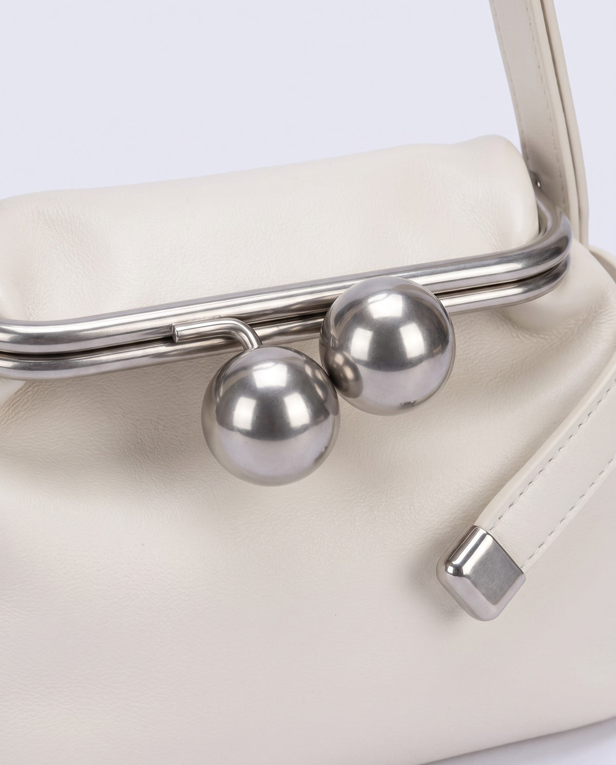 Silver kiss-lock clasp detail on the Garda frame bag in Ivory