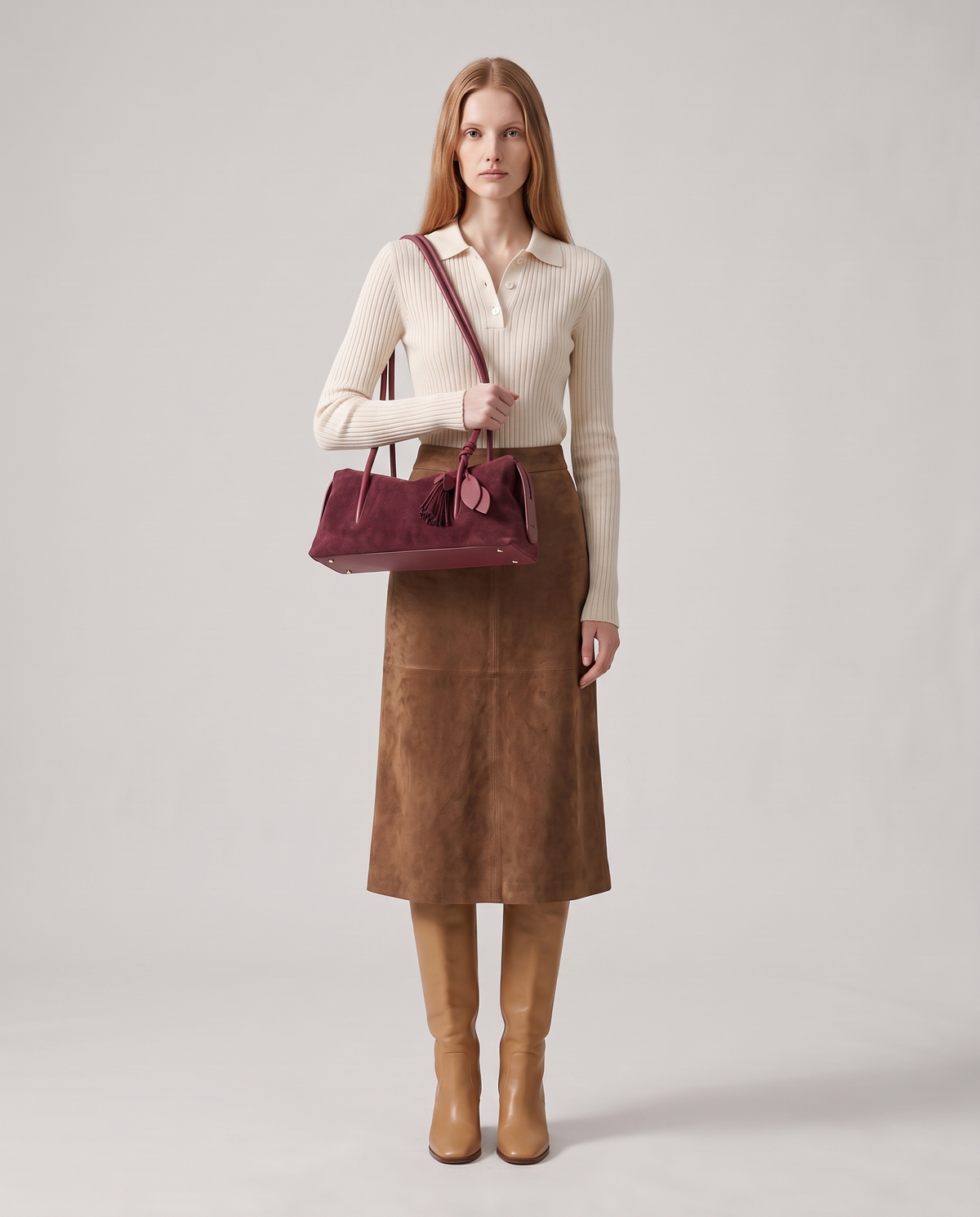 Model carrying the Isola suede shoulder bag in burgundy, full length