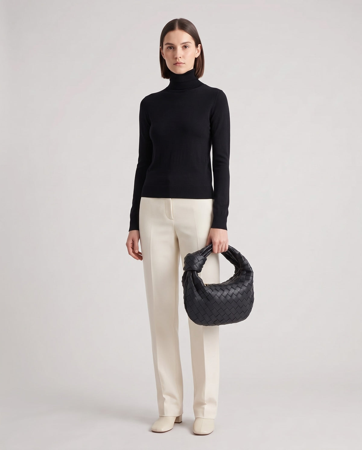 Knot Midi woven leather bag in Black – model holding it, full length
