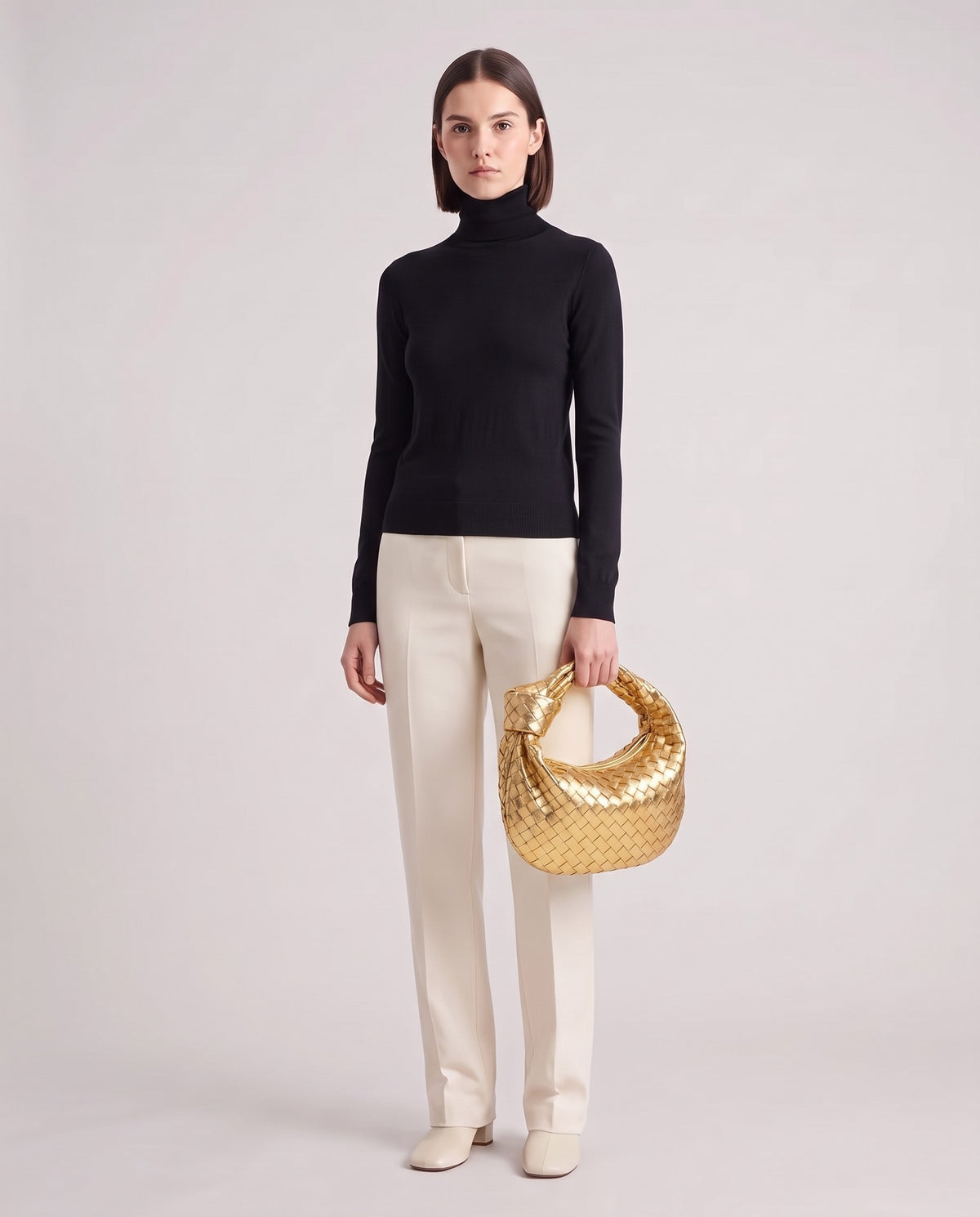 Knot Midi woven leather bag in Gold – model holding it, full length