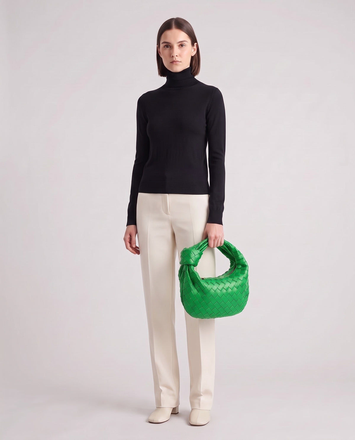 Knot Midi woven leather bag in Green – model holding it, full length