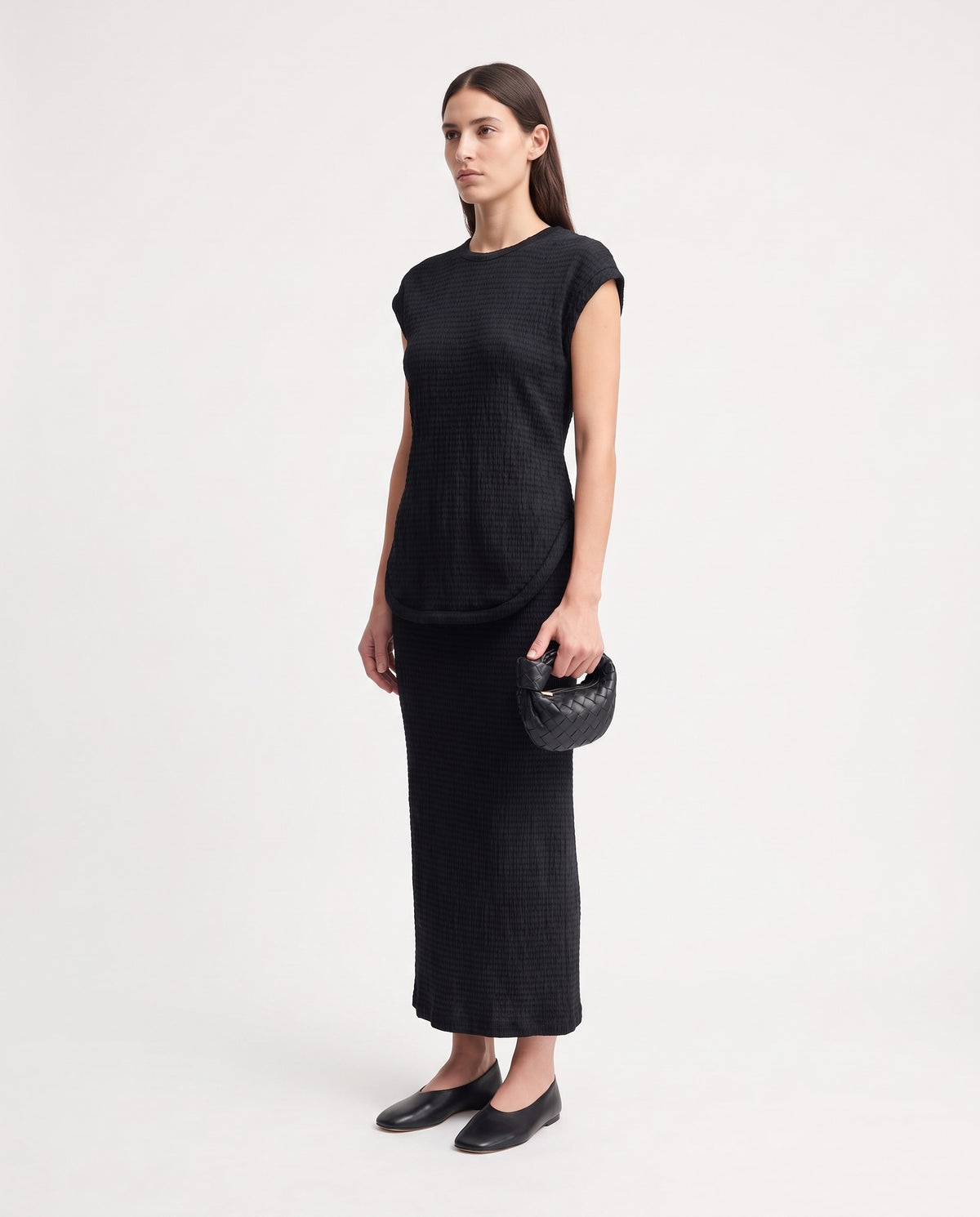 Knot Mini woven leather bag in Black – model holding it, full length