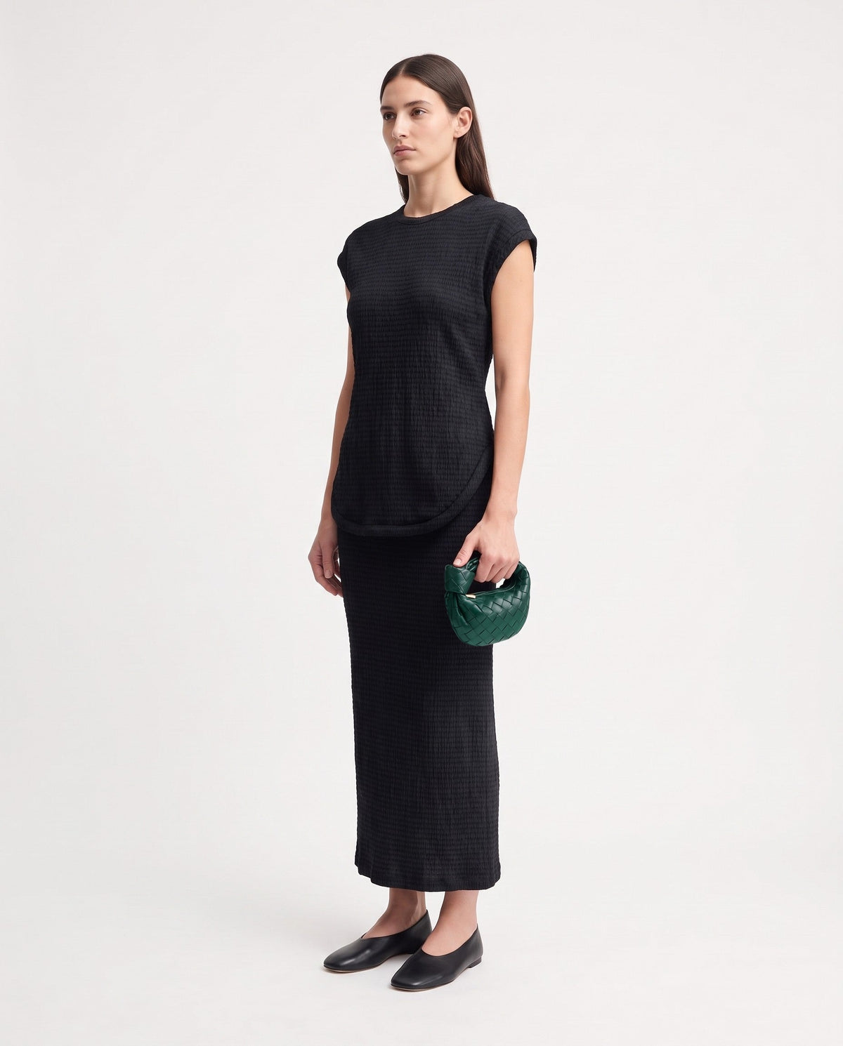 Knot Mini woven leather bag in Emerald – model holding it, full length