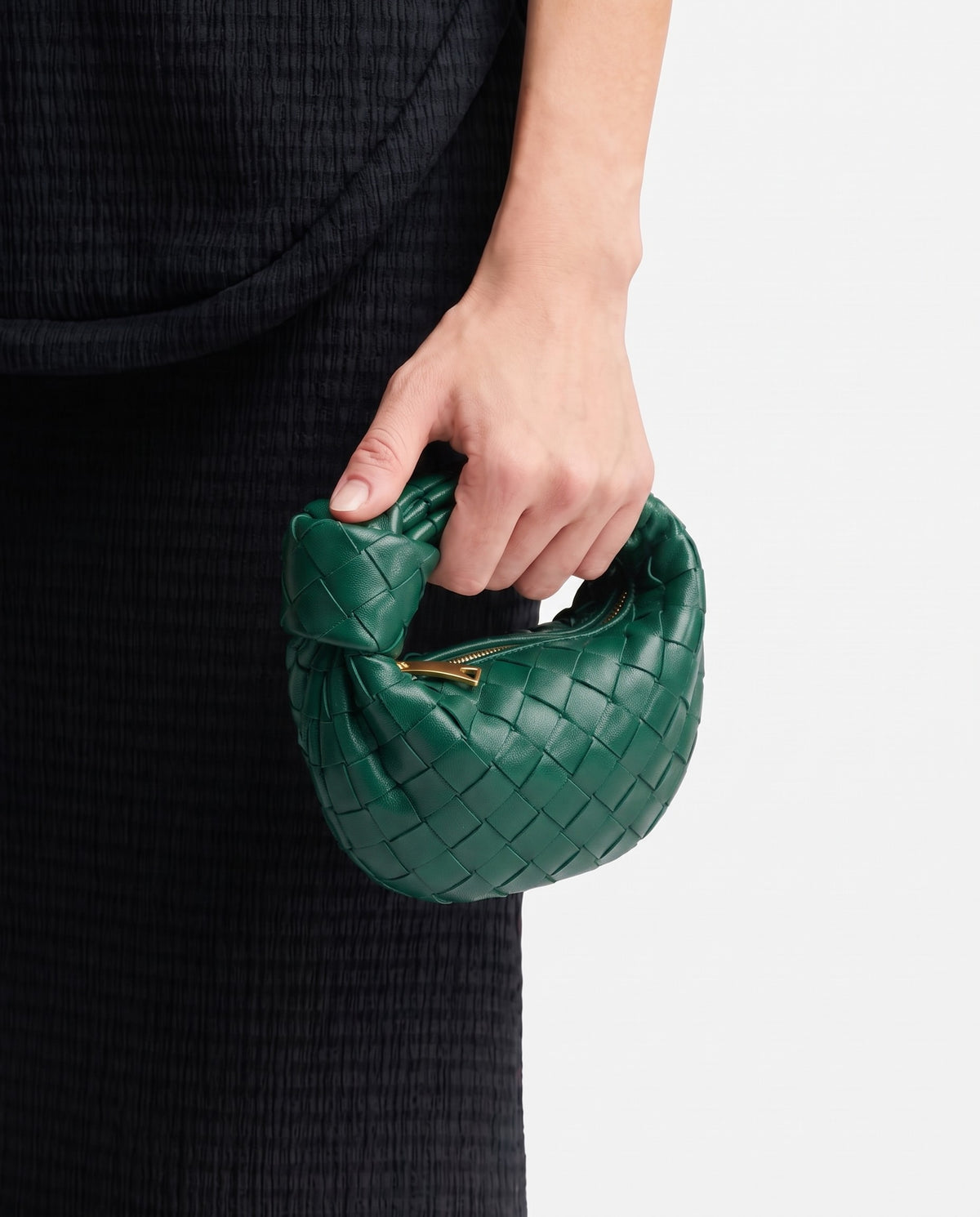 Knot Mini woven leather bag in Emerald – held in the hand, showing true size