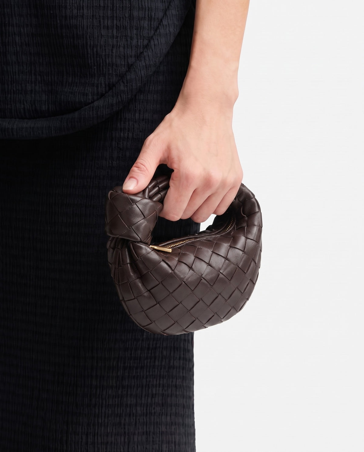 Knot Mini woven leather bag in Espresso – held in the hand, showing true size