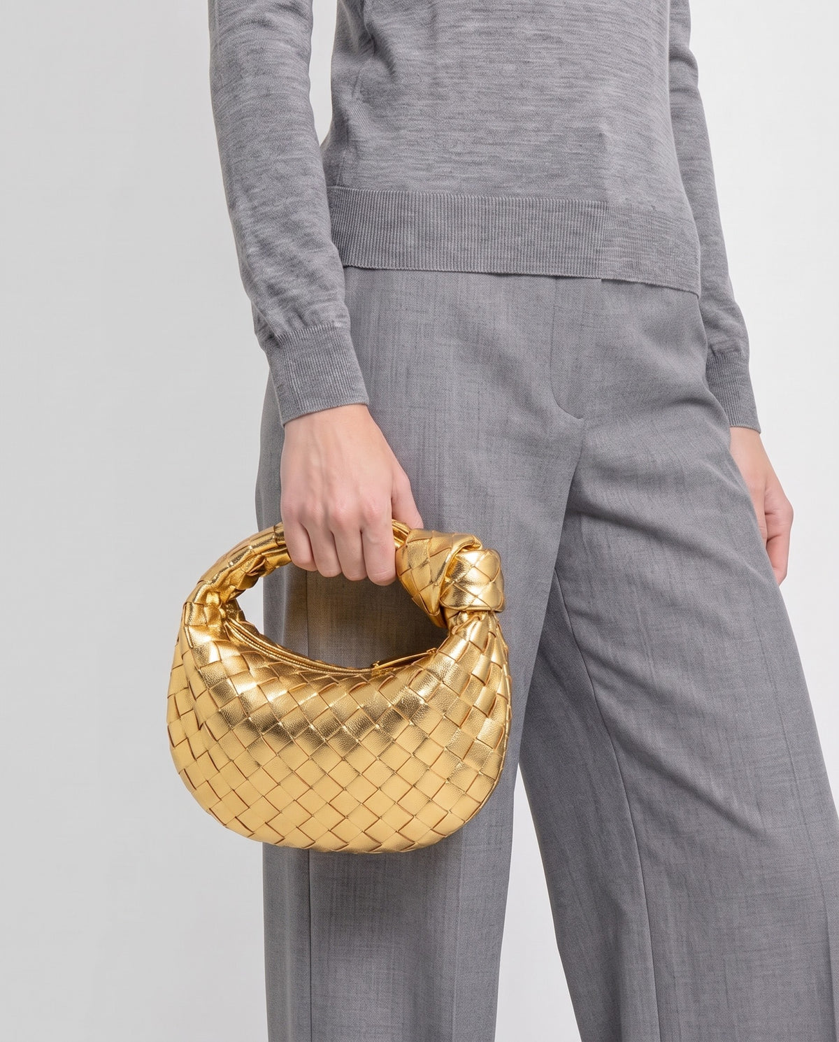 Knot Mini woven leather bag in Gold – model carrying it