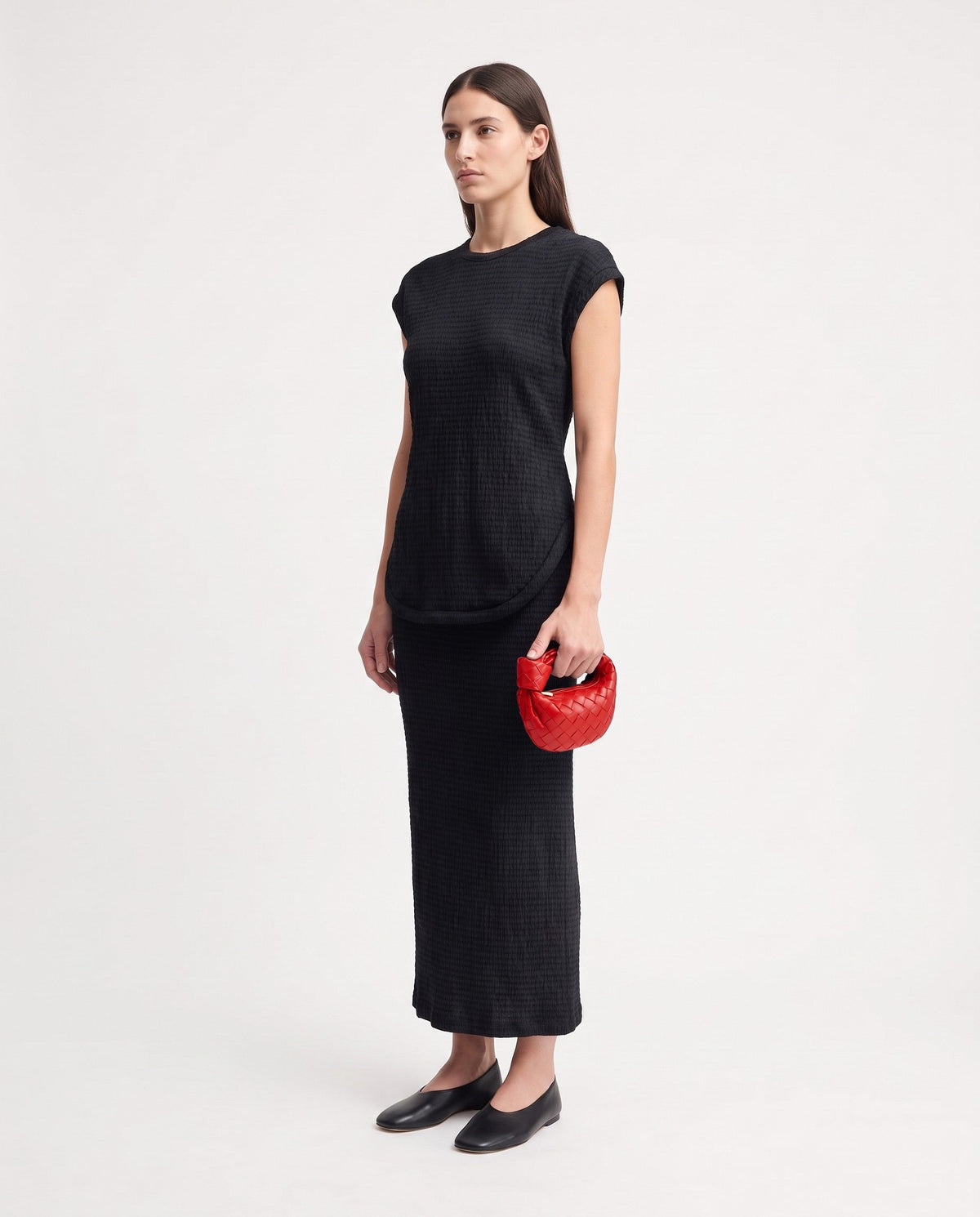 Knot Mini woven leather bag in Scarlet – model holding it, full length