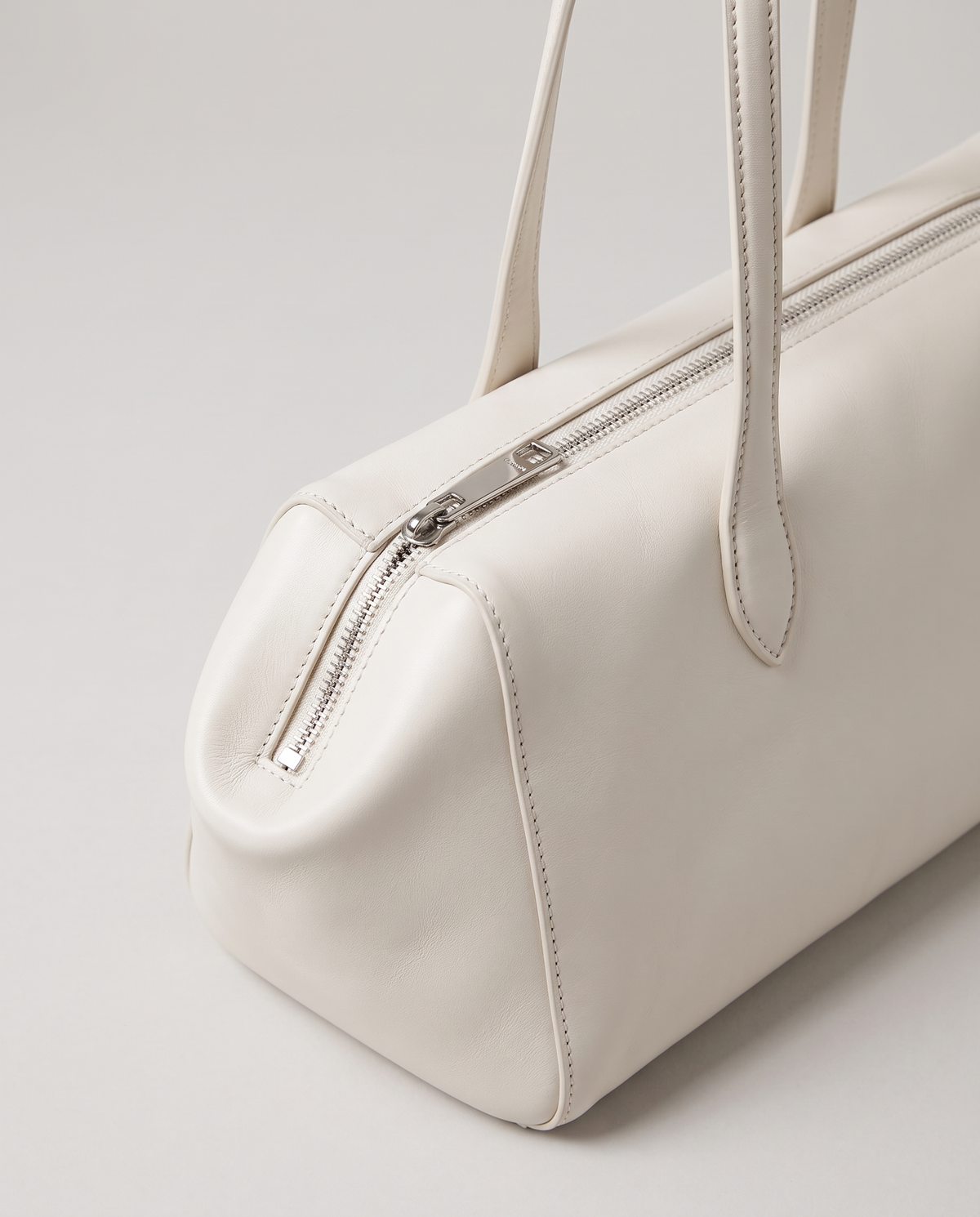 Lira leather shoulder bag in White – close-up of the zip and strap join