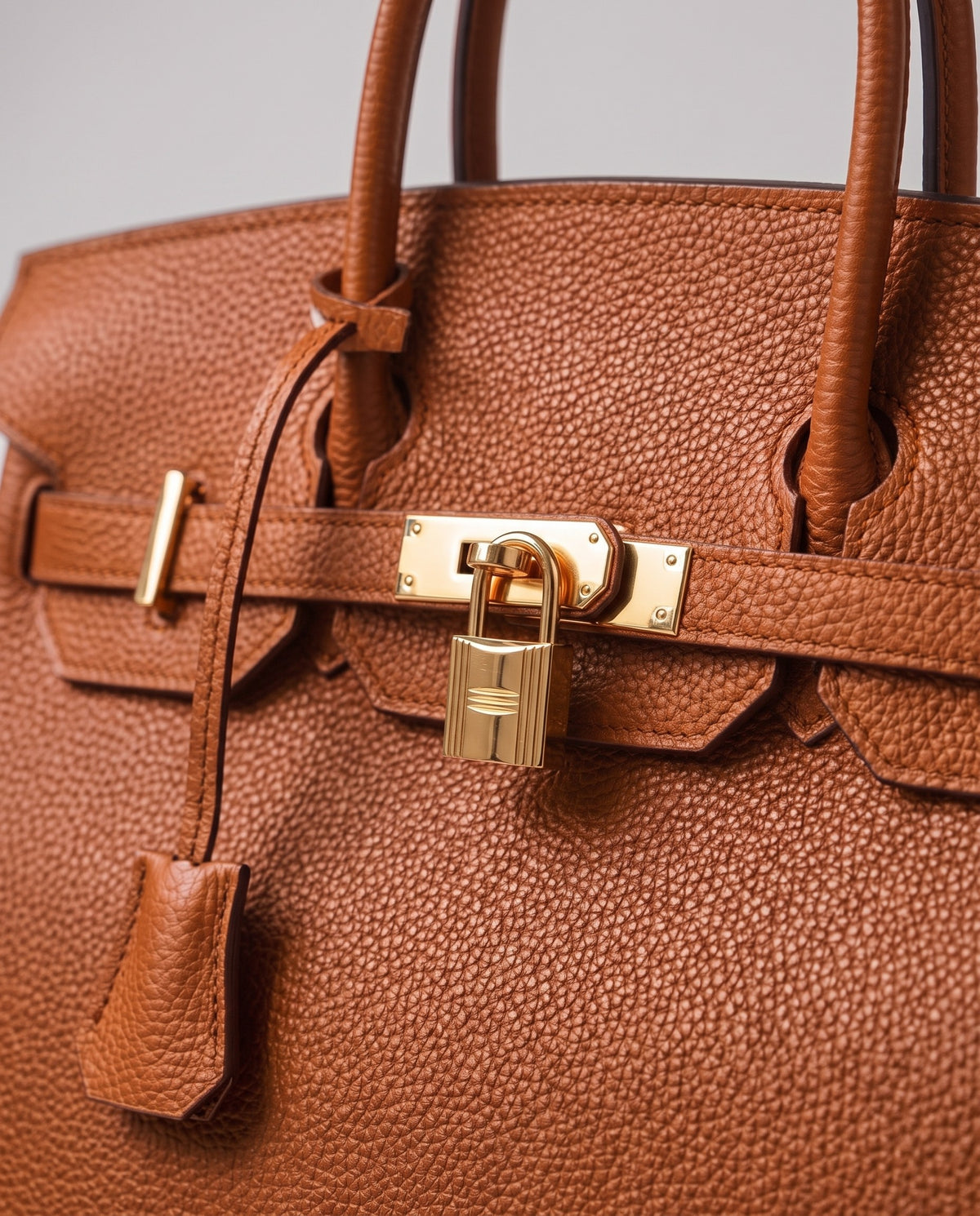 Lock Large leather top-handle bag in Caramel – close-up of the gold turn-lock and padlock