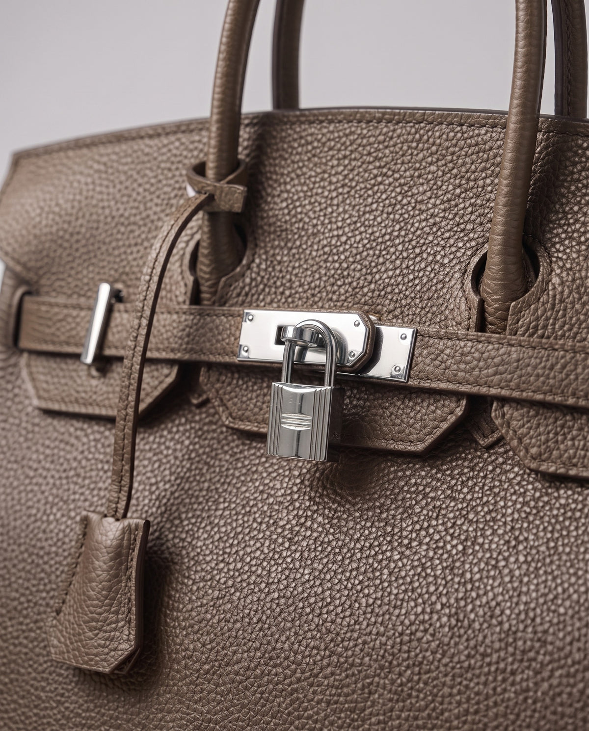Lock Large leather top-handle bag in Taupe – close-up of the silver turn-lock and padlock
