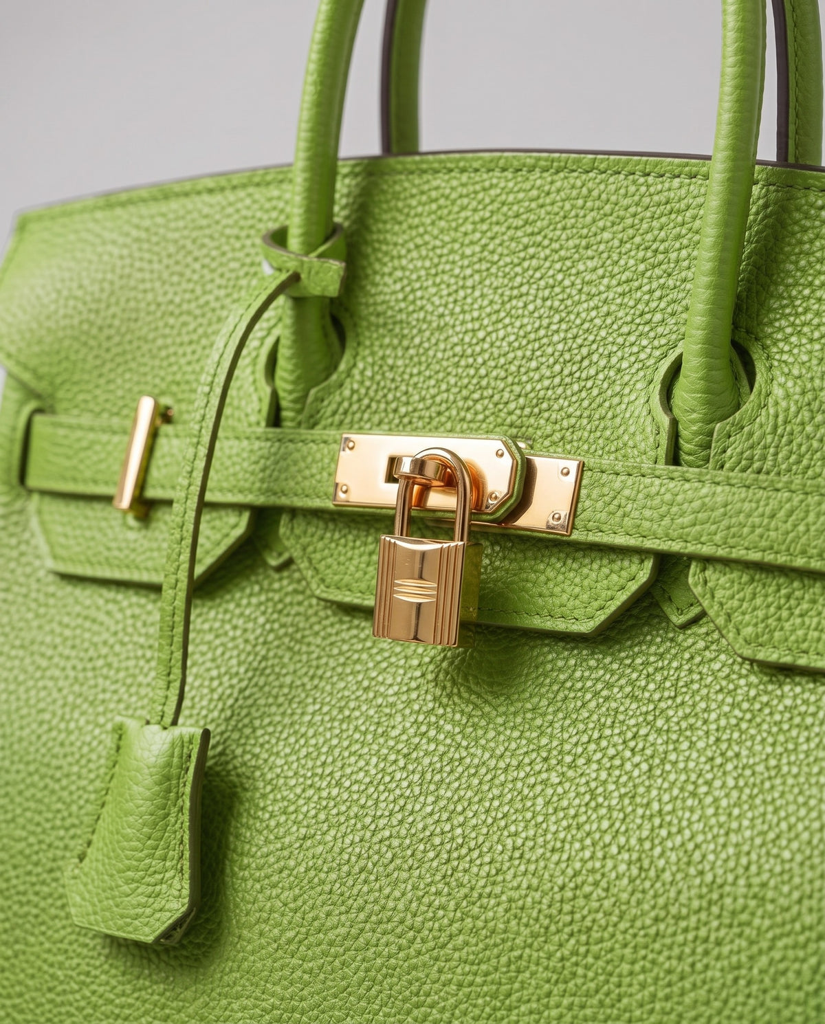 Lock Medium leather top-handle bag in Avocado – close-up of the gold turn-lock and padlock