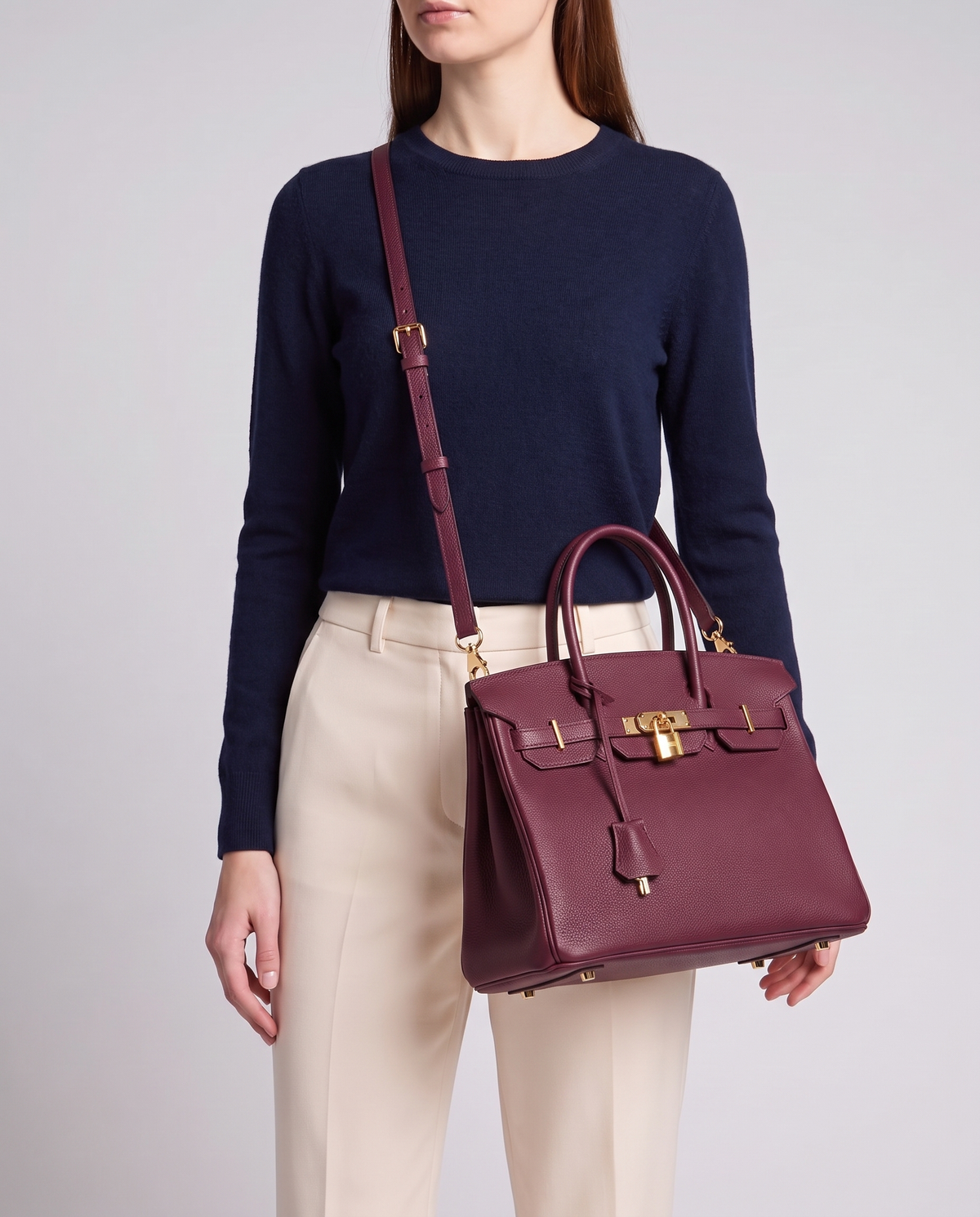 Lock Medium leather top-handle bag in Bordeaux – model wearing it crossbody on the detachable shoulder strap