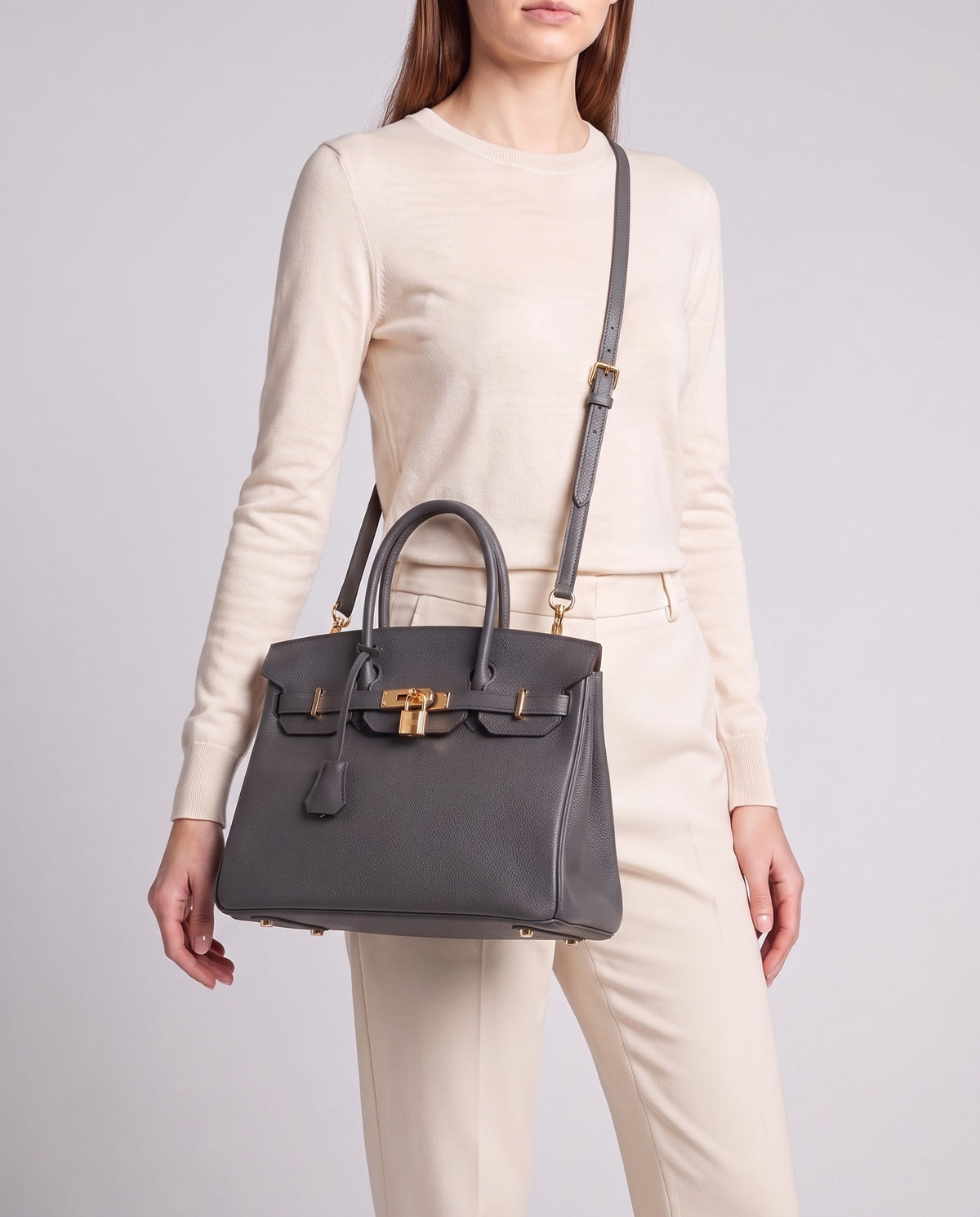 Lock Medium leather top-handle bag in Charcoal – model wearing it crossbody on the detachable shoulder strap