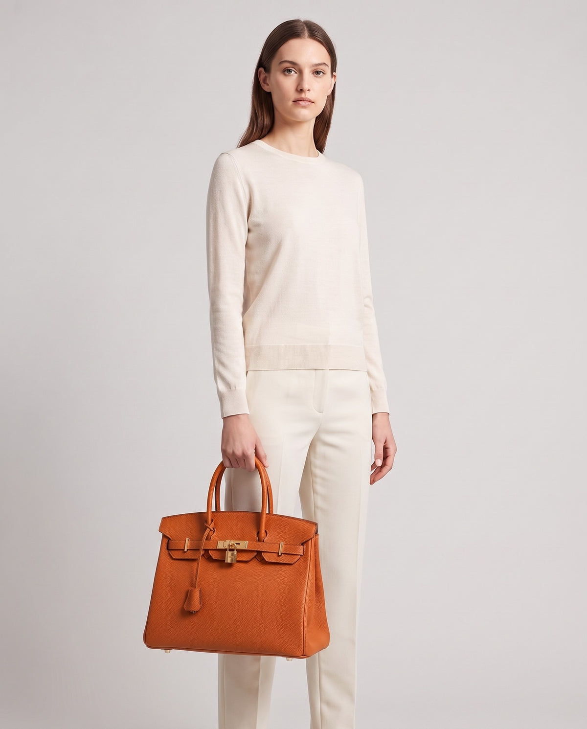 Lock Medium leather top-handle bag in Terracotta – model holding it, full length