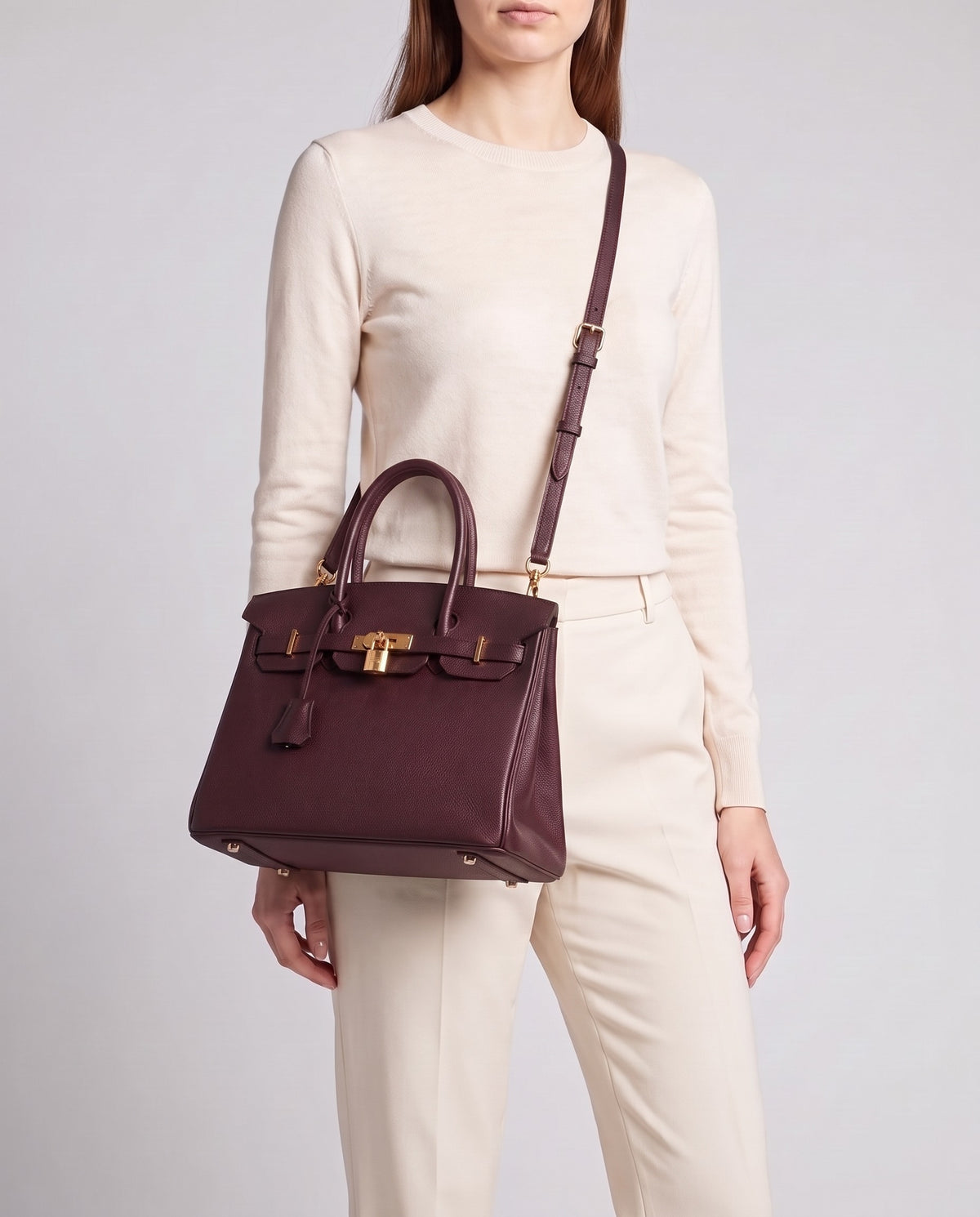 Lock Small leather top-handle bag in Bordeaux – model wearing it crossbody on the detachable shoulder strap