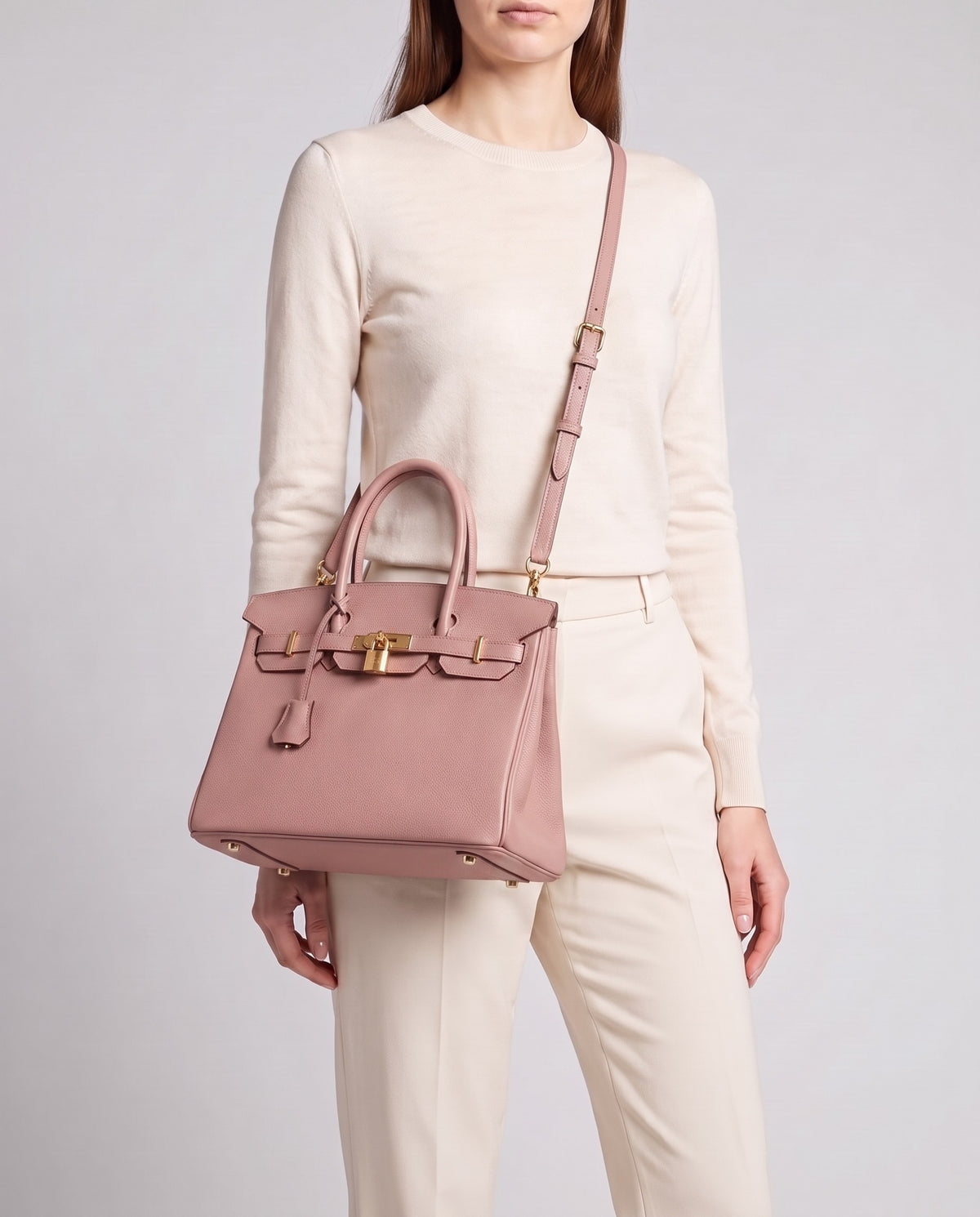 Lock Small leather top-handle bag in Pink – model wearing it crossbody on the detachable shoulder strap