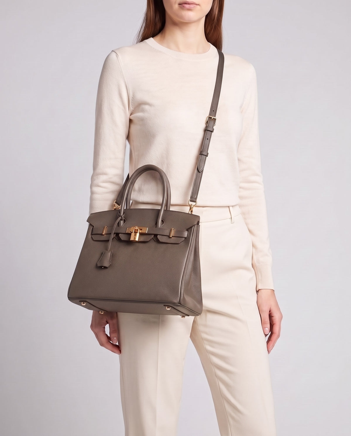 Lock Small leather top-handle bag in Taupe – model wearing it crossbody on the detachable shoulder strap