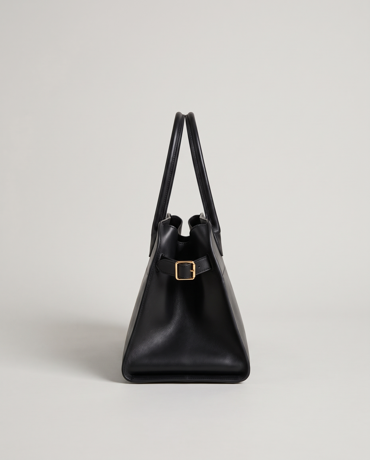 Milano Small top-handle bag in Black – side view showing the buckled side strap