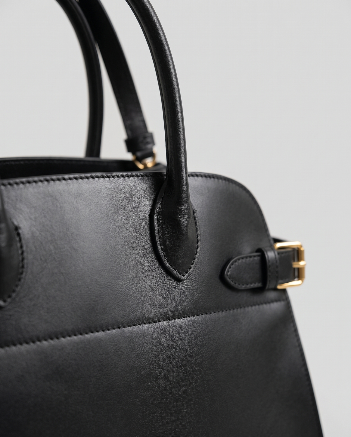 Milano Small top-handle bag in Black – close-up of the handle and gold side buckle