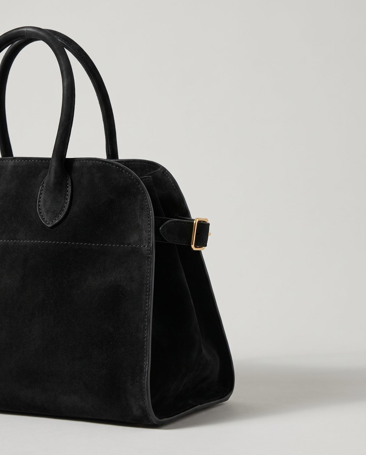 Milano Small top-handle bag in Jet suede – close-up of the handle and gold side buckle