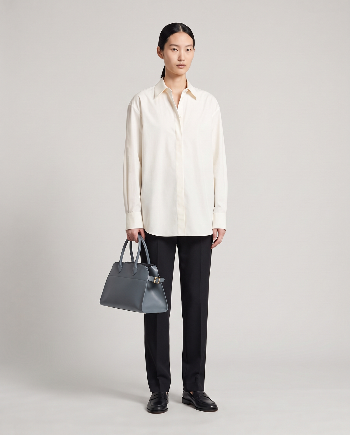 Milano Small top-handle bag in Slate – model holding it by the top handles, full length