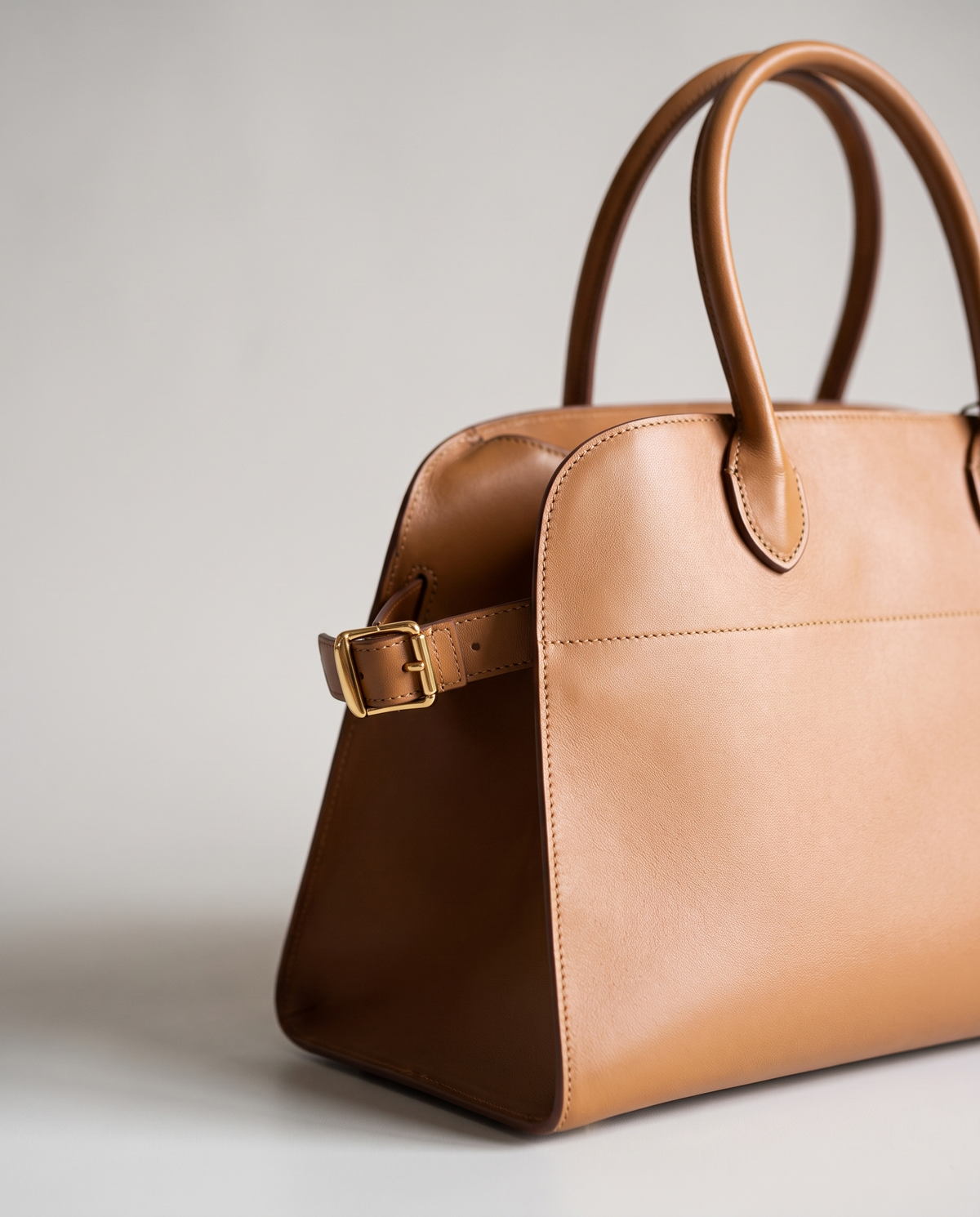 Milano Small top-handle bag in Tan – close-up of the handle and gold side buckle