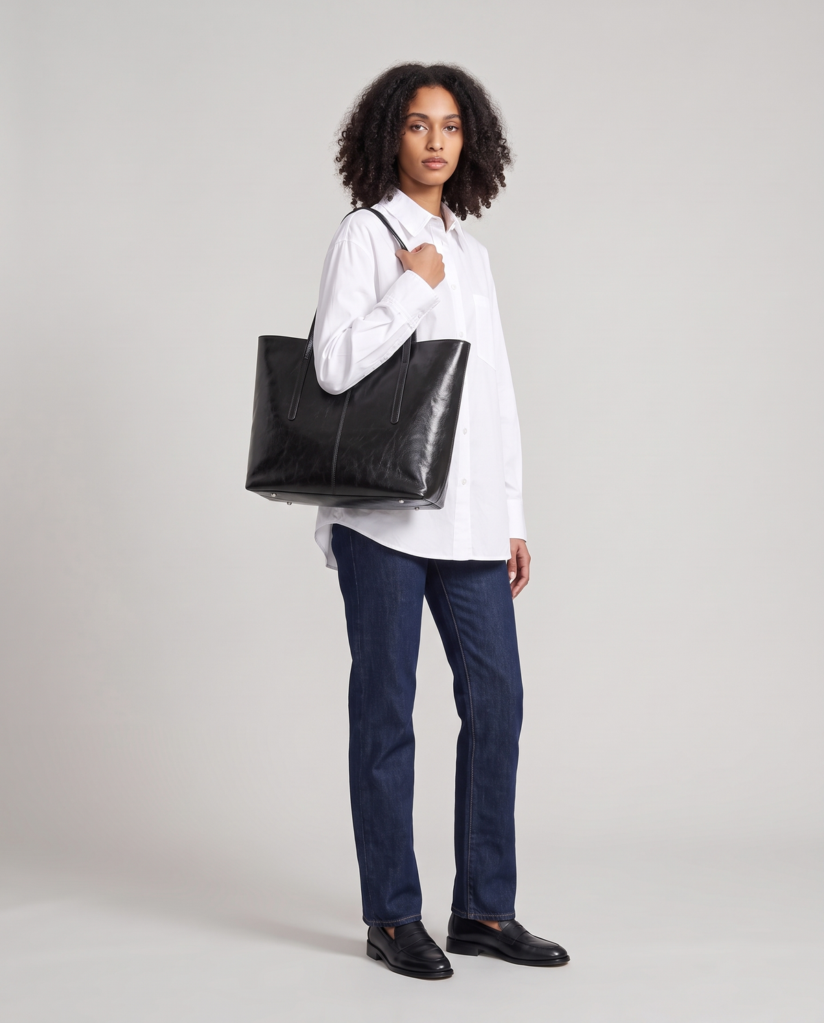 Model with the Molo oil-waxed leather tote in black, full length