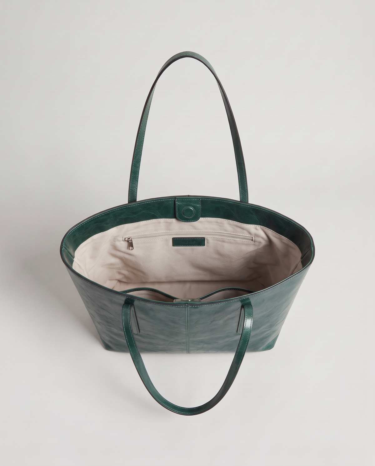 Molo oil-waxed leather tote in emerald, open showing interior