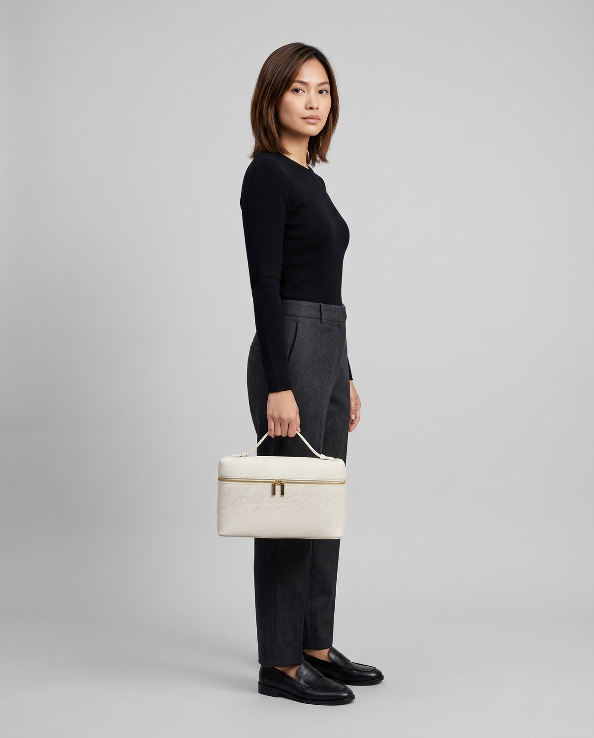 Model holding the Orvieto vanity case in Ivory – full-length view