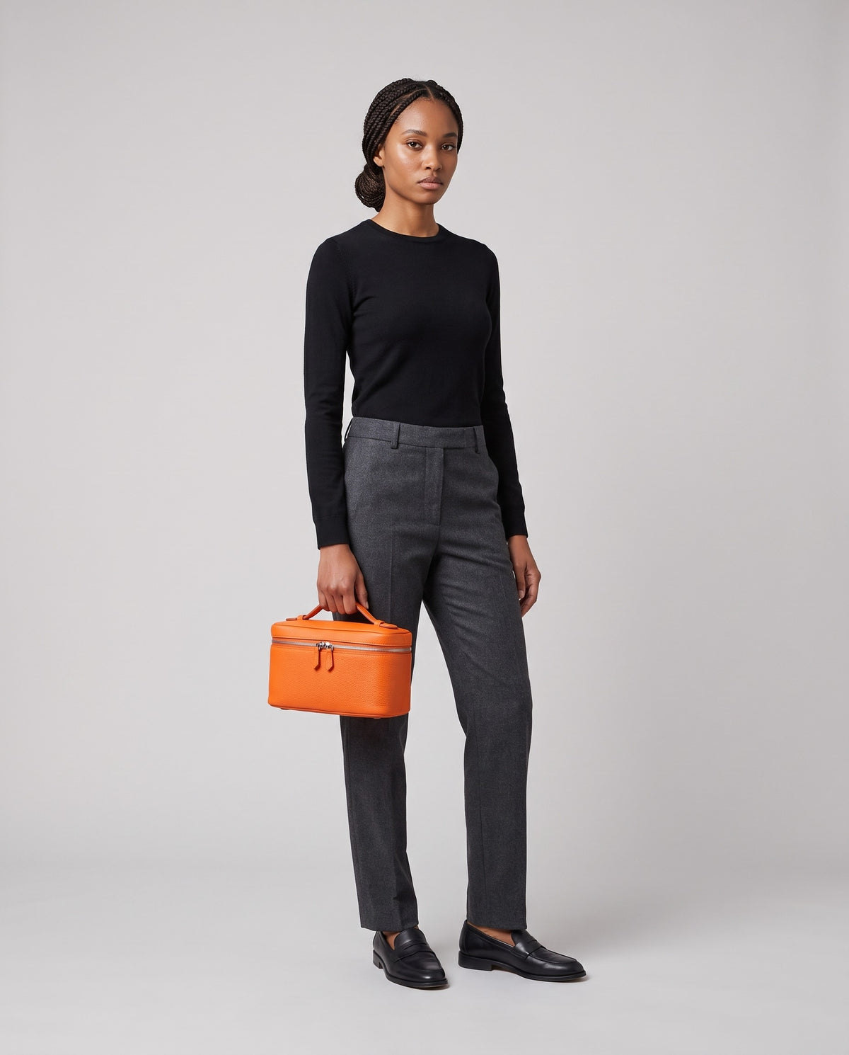 Model holding the Orvieto vanity case in Orange – full-length view